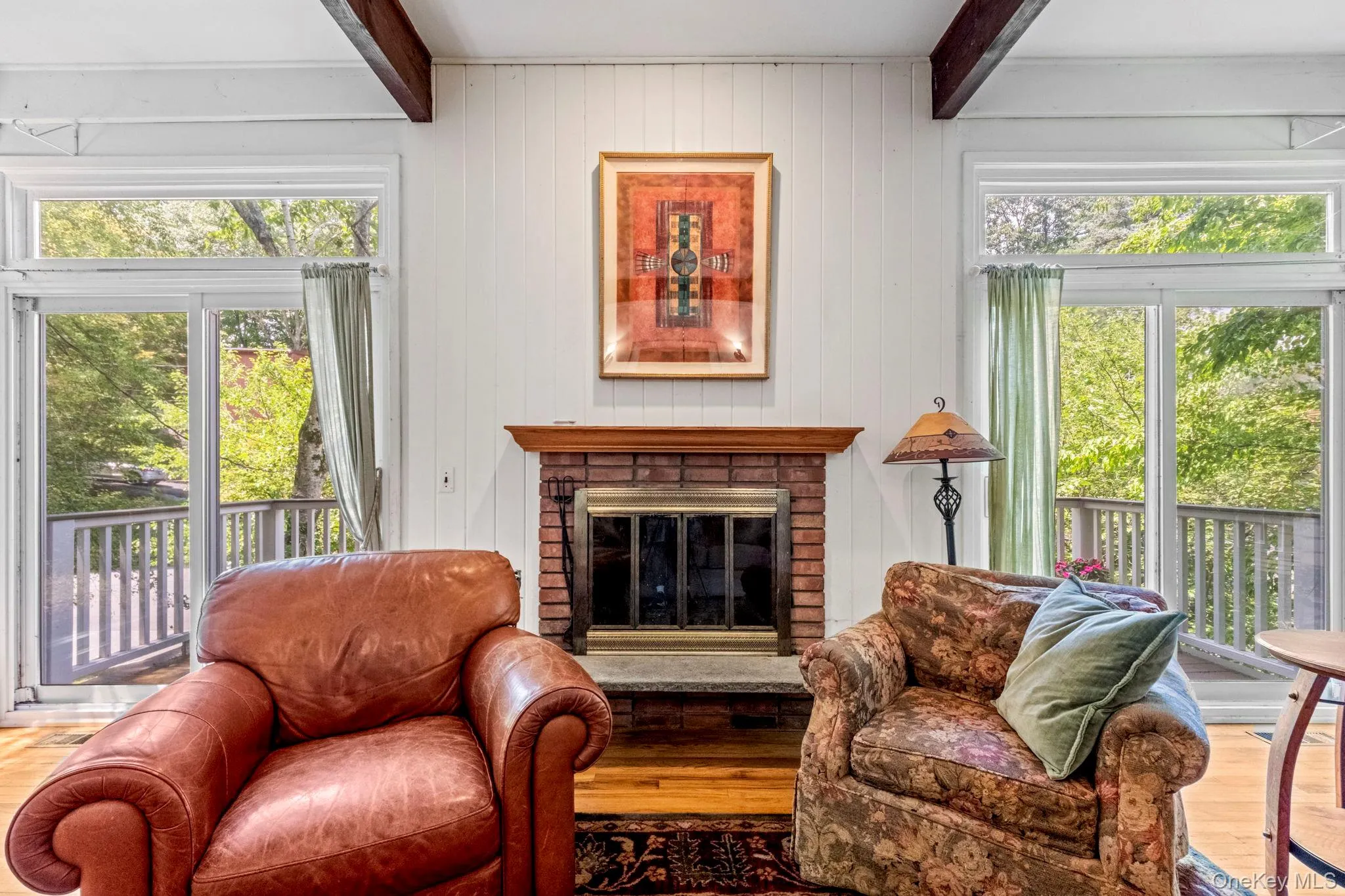 Living room features a working fireplace with two sliding glass doors opening to the front deck Living room features a working fireplace with two sliding glass doors opening to the front deck