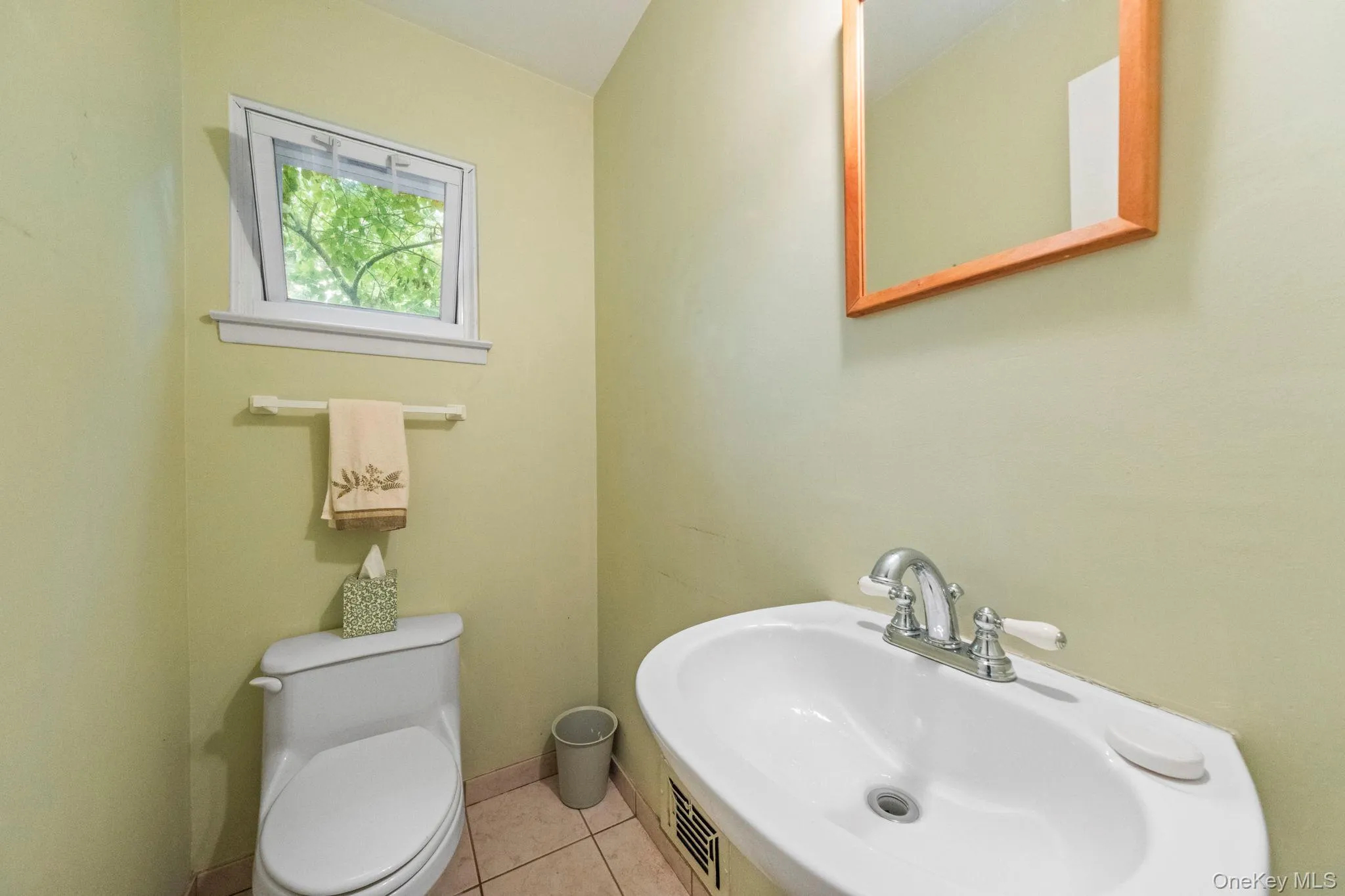 Half bathroom featuring a corner sink with chrome faucet, light-toned wall paint, and tile flooring Half bathroom featuring a corner sink with chrome faucet, light-toned wall paint, and tile flooring