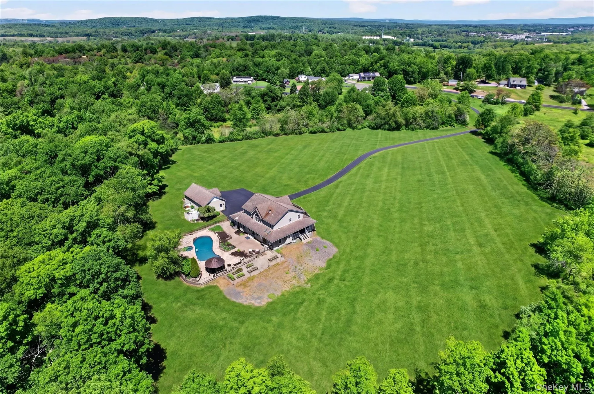A sweeping aerial view shows the home surrounded by open lawn, mature trees, and rolling scenery, offering a wonderful sense of privacy and space. The mowed area reflects roughly 5 acres of the entire 44+ acre parcel! A sweeping aerial view shows the home surrounded by open lawn, mature trees, and rolling scenery, offering a wonderful sense of privacy and space. The mowed area reflects roughly 5 acres of the entire 44+ acre parcel!