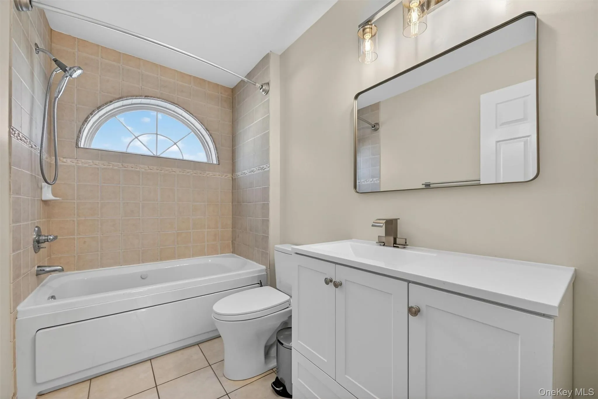 This bathroom is fresh, clean and comfortable, with a bright vanity, tiled tub area, and a charming arched window that brings in natural light. Located on the second floor, this bath serves both the 3rd bedroom and the home office. This bathroom is fresh, clean and comfortable, with a bright vanity, tiled tub area, and a charming arched window that brings in natural light. Located on the second floor, this bath serves both the 3rd bedroom and the home office.
