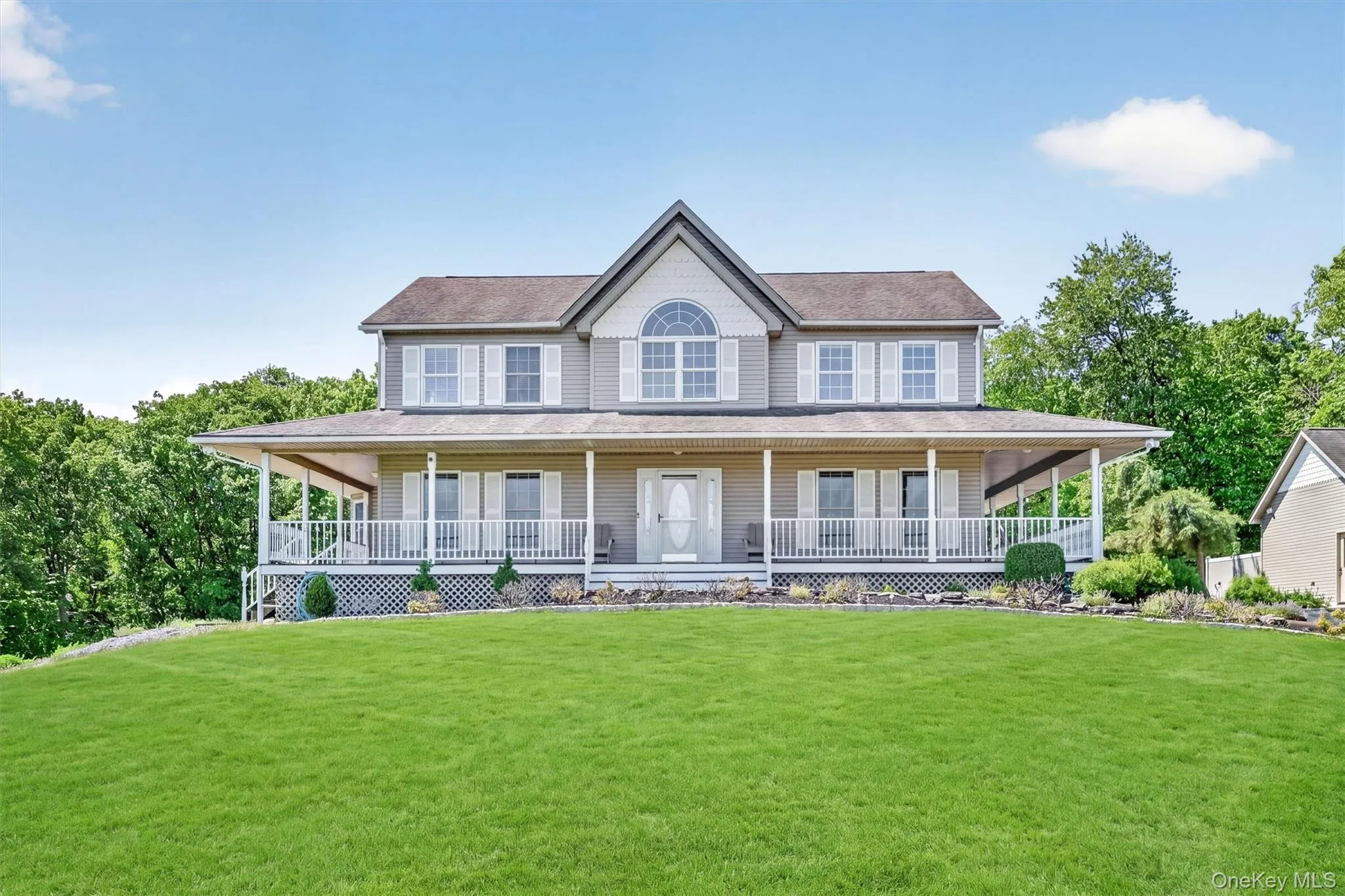 A picture-perfect front view highlights the charm of the home, from the broad porch to the gently rolling lawn that frames it. A picture-perfect front view highlights the charm of the home, from the broad porch to the gently rolling lawn that frames it.