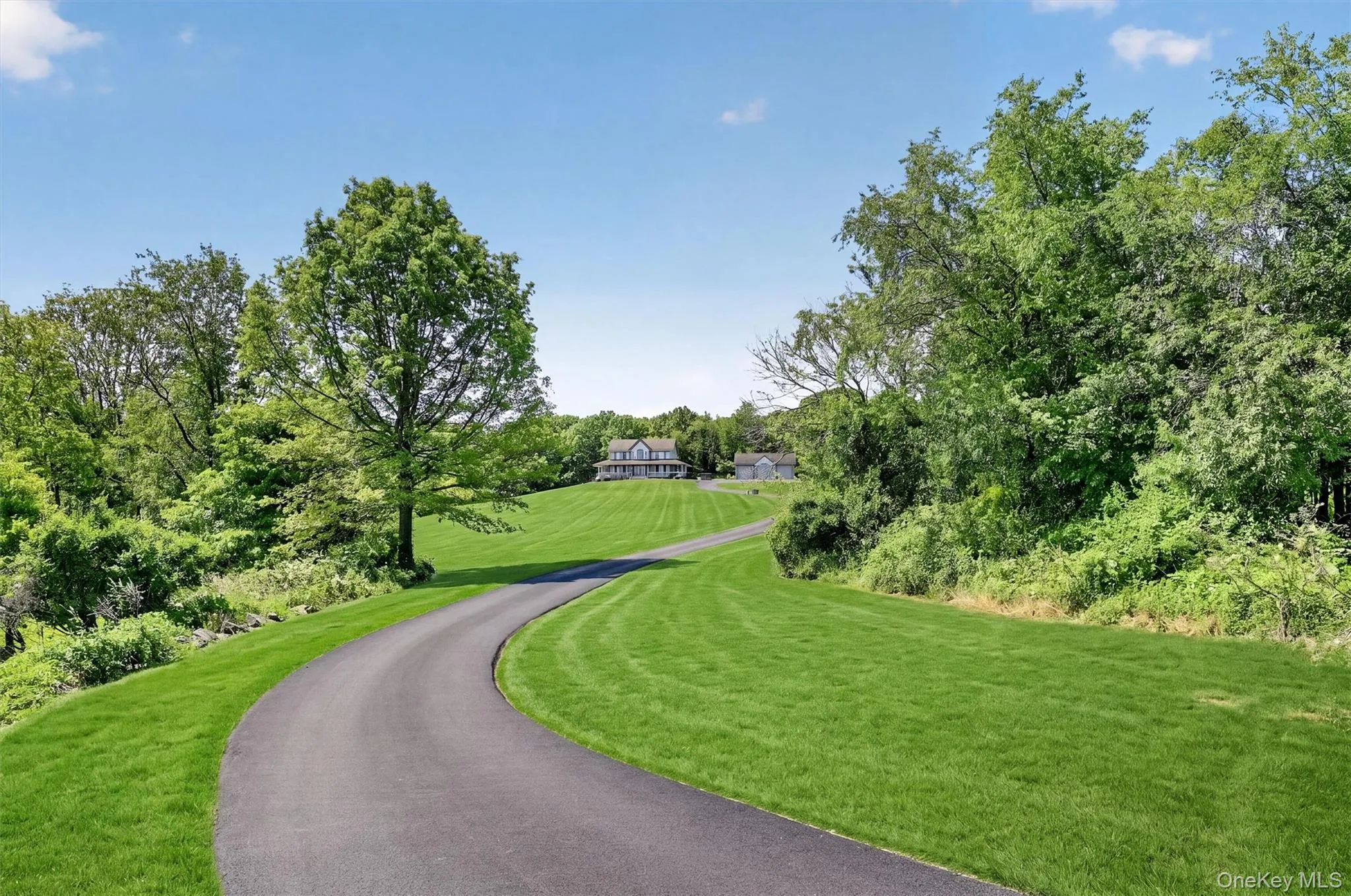 The long private driveway creates a true sense of arrival, leading you through the green landscape toward a home tucked peacefully into its surroundings. The long private driveway creates a true sense of arrival, leading you through the green landscape toward a home tucked peacefully into its surroundings.