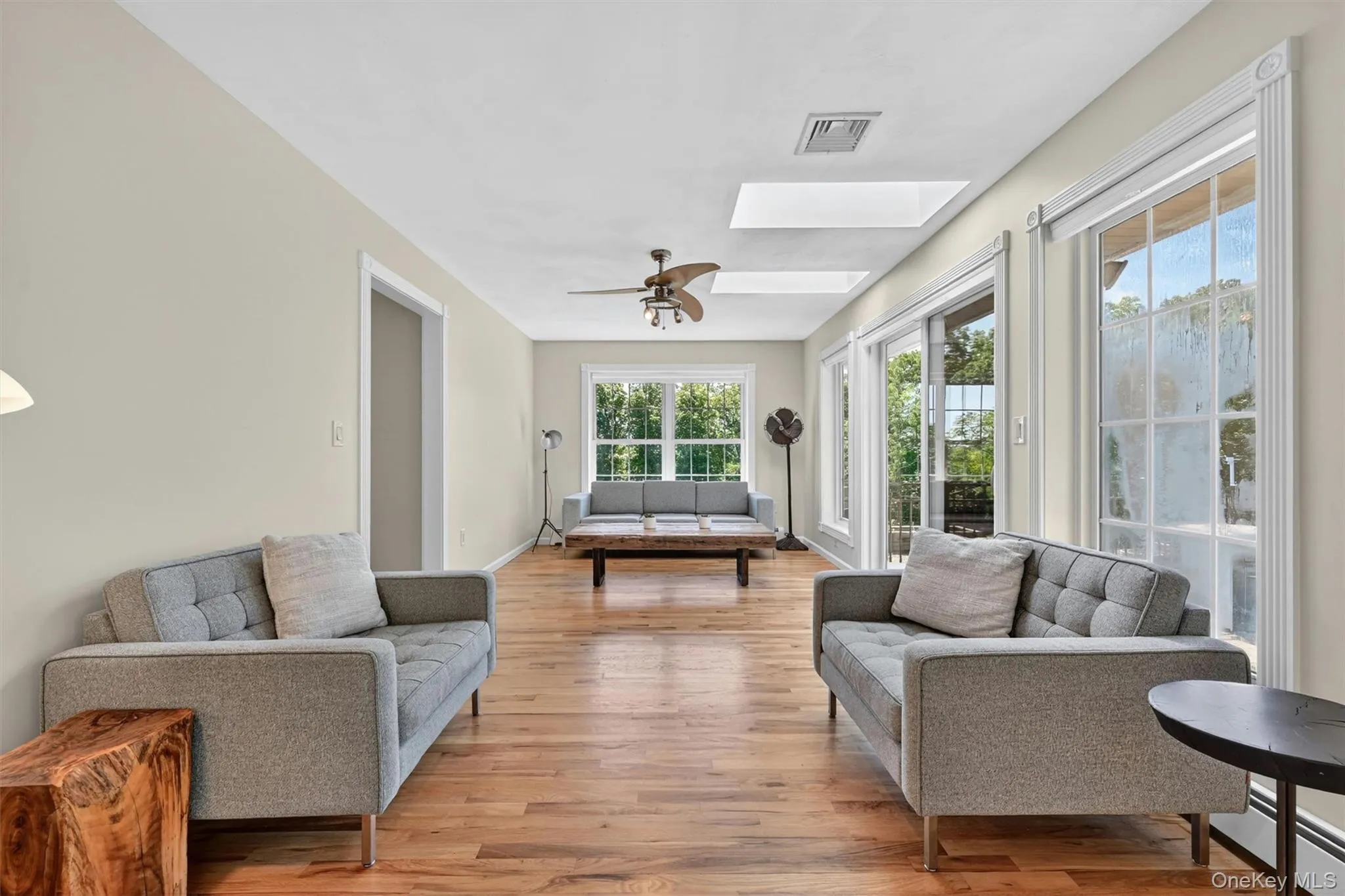 A slightly different angle of this sun-filled family room. A calm and welcoming space, with skylights, beautifully refinished hardwood floors, and windows that draw your eye toward the outdoor living space. A slightly different angle of this sun-filled family room. A calm and welcoming space, with skylights, beautifully refinished hardwood floors, and windows that draw your eye toward the outdoor living space.