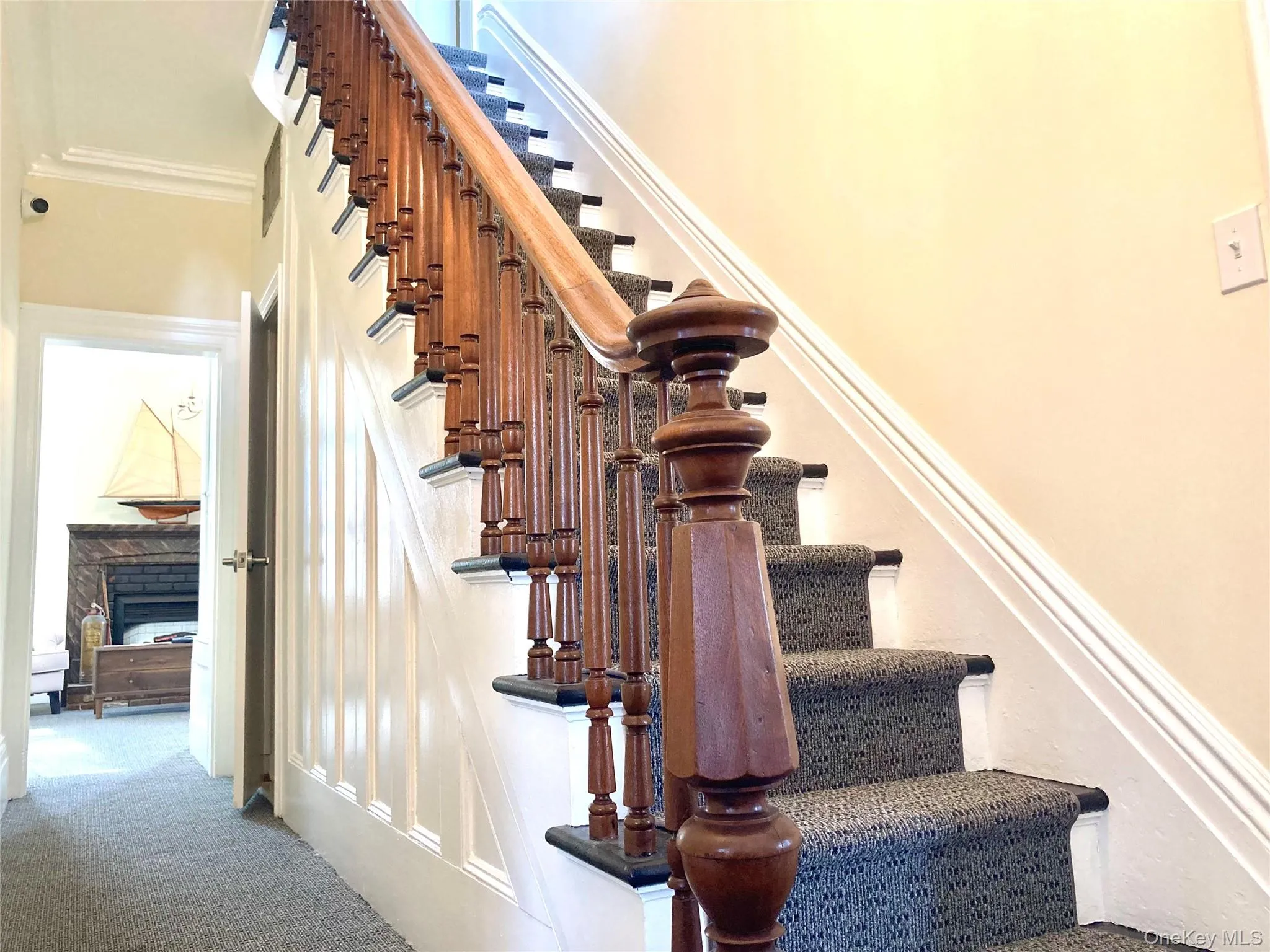 Stairs with a fireplace, carpet floors, and ornamental molding Stairs with a fireplace, carpet floors, and ornamental molding