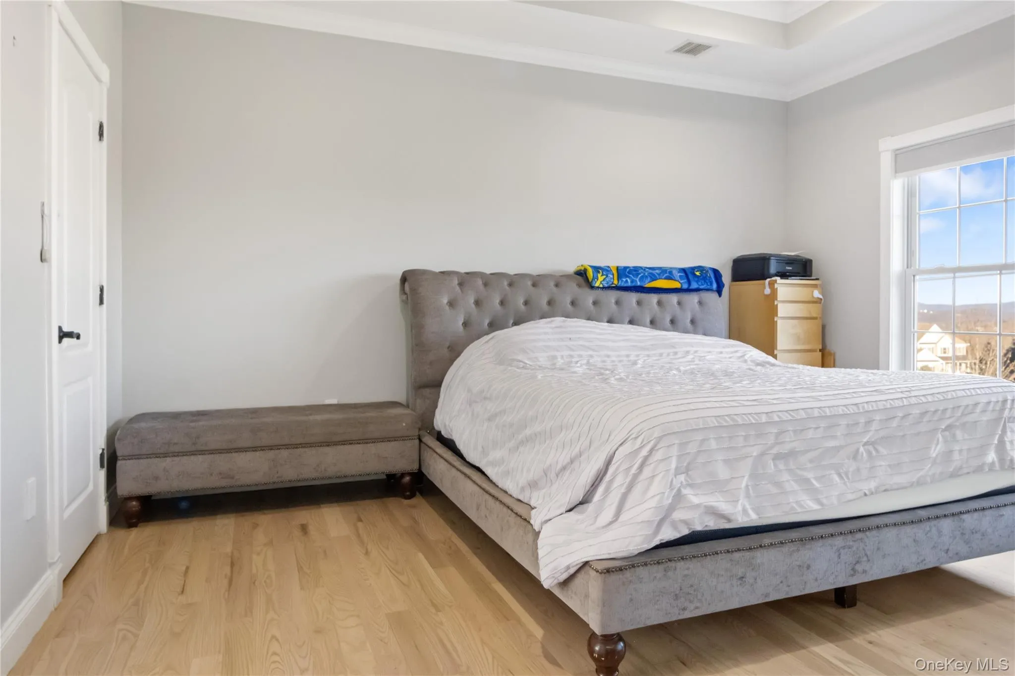 Bedroom featuring wood finished floors and ornamental molding Bedroom featuring wood finished floors and ornamental molding