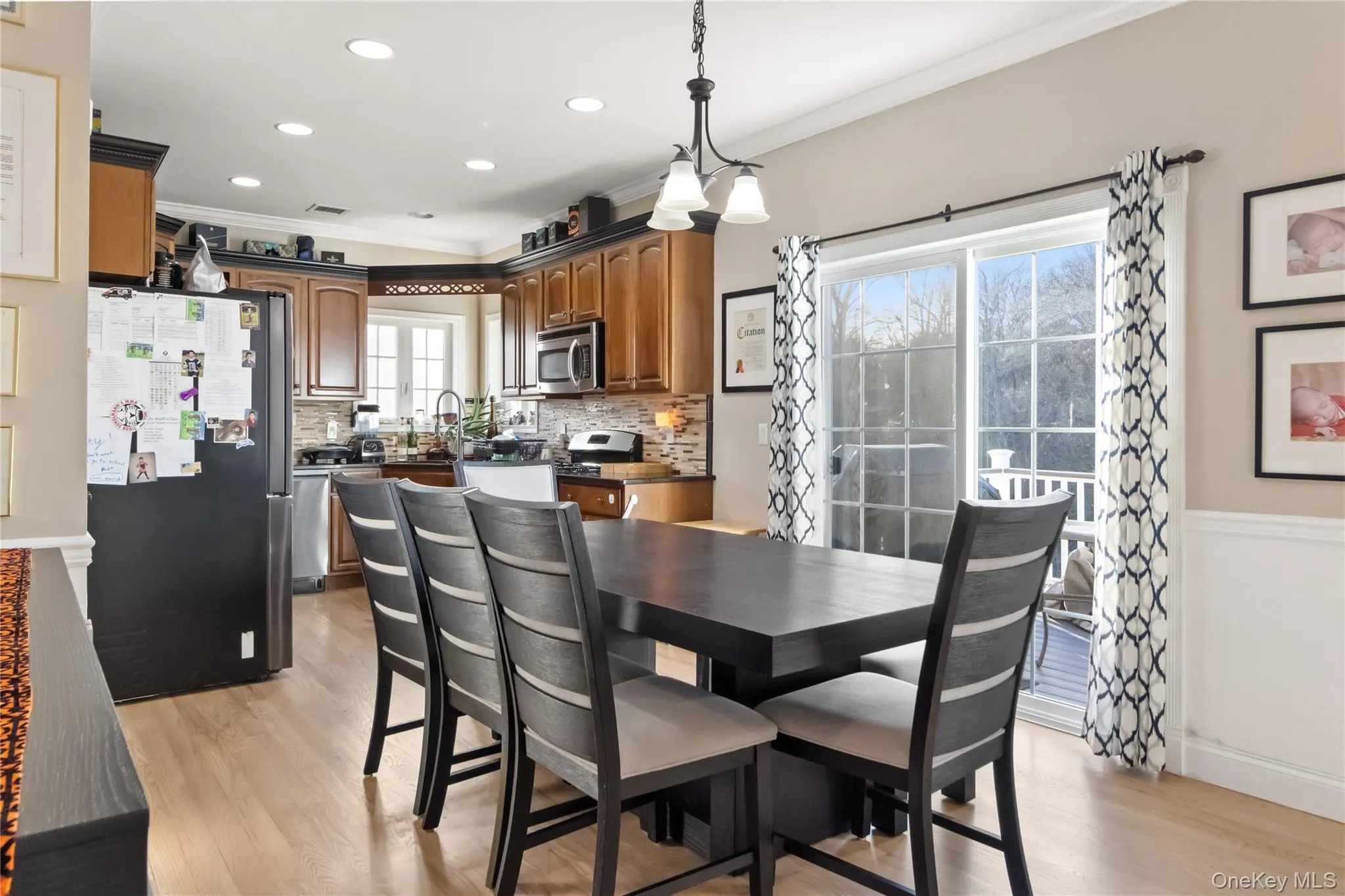 Dining room featuring ornamental molding, light wood-style floors, wainscoting, and recessed lighting Dining room featuring ornamental molding, light wood-style floors, wainscoting, and recessed lighting