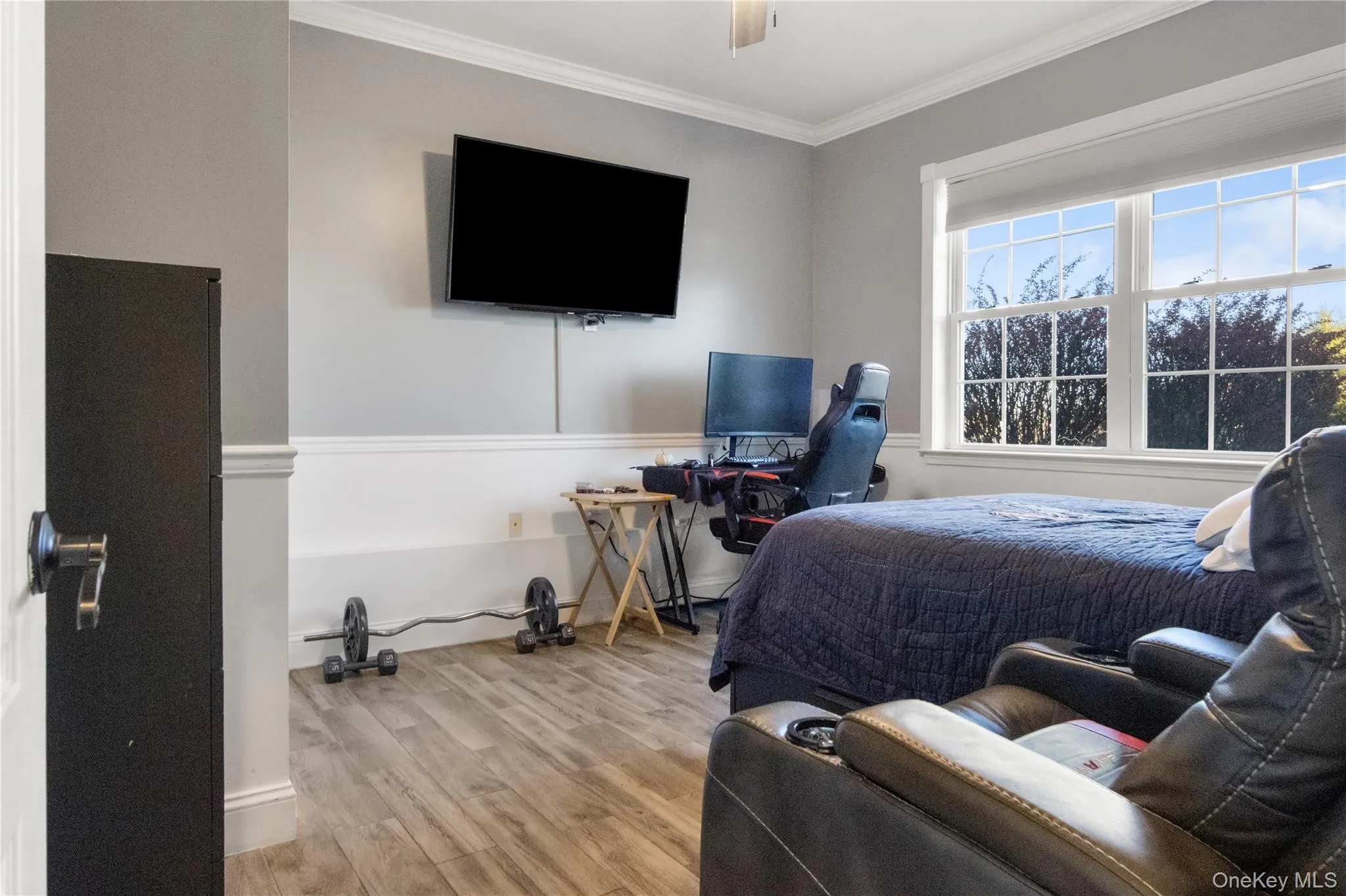 Bedroom featuring ornamental molding, wood finished floors, and ceiling fan Bedroom featuring ornamental molding, wood finished floors, and ceiling fan