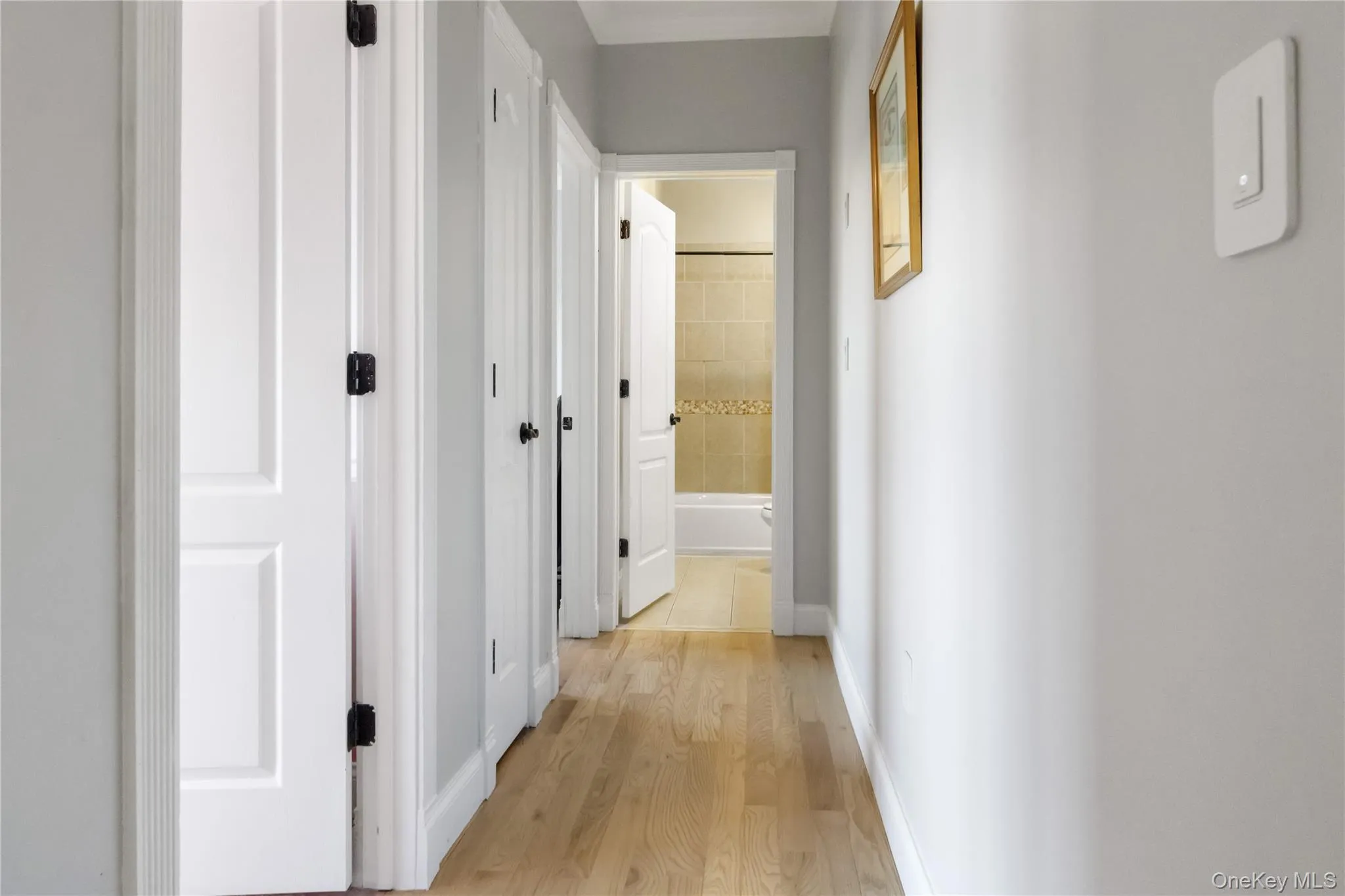 Hallway with light wood-type flooring and baseboards Hallway with light wood-type flooring and baseboards