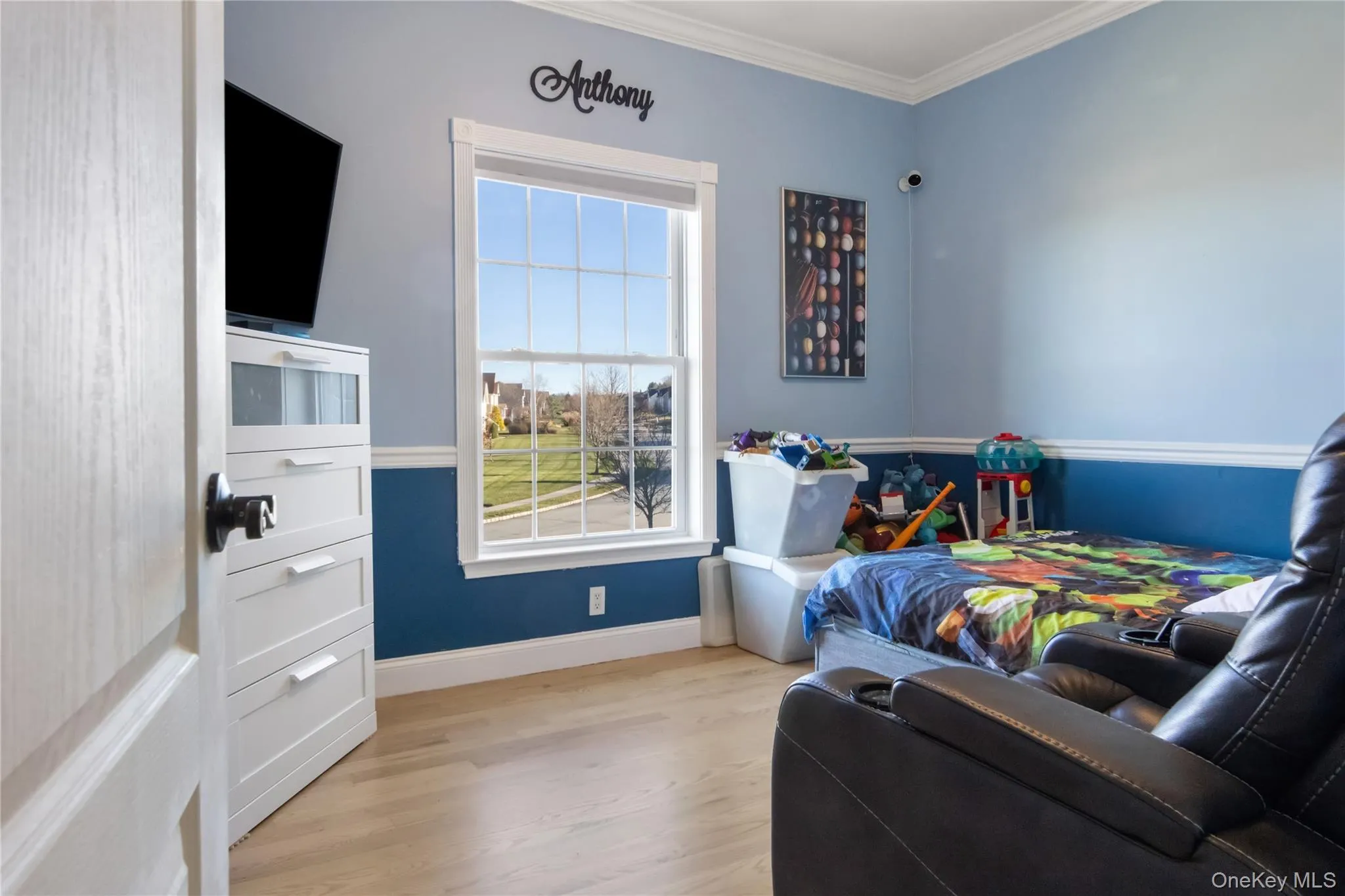 Bedroom with light wood-type flooring and crown molding Bedroom with light wood-type flooring and crown molding