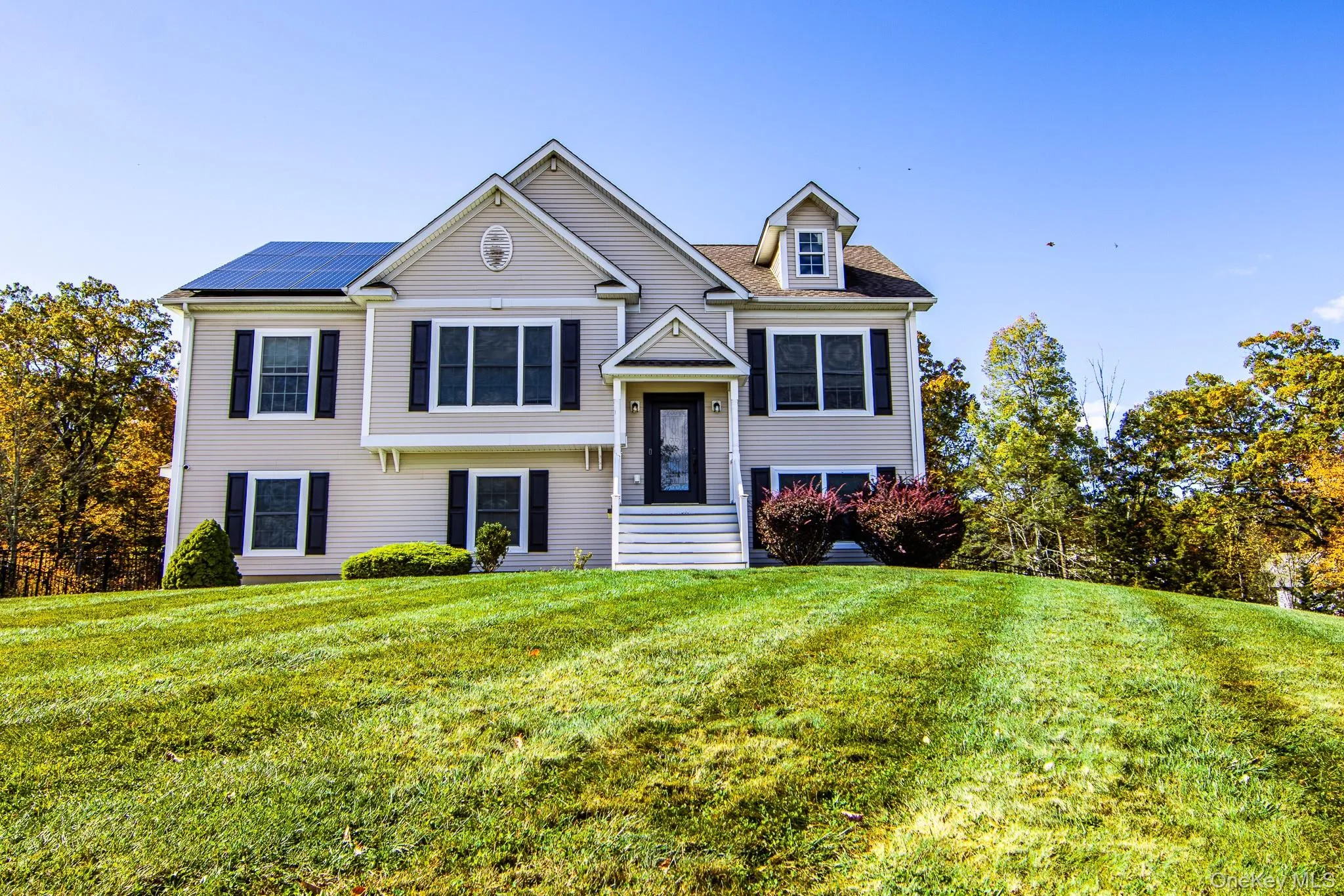 Raised ranch with solar panels and a front yard Raised ranch with solar panels and a front yard