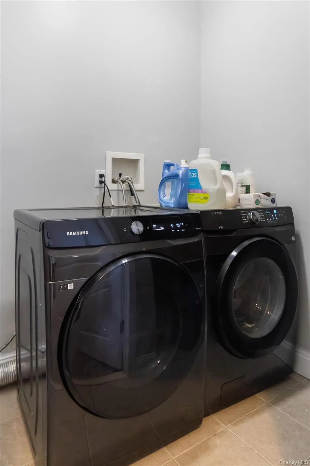 Laundry area featuring light tile patterned floors and independent washer and dryer Laundry area featuring light tile patterned floors and independent washer and dryer