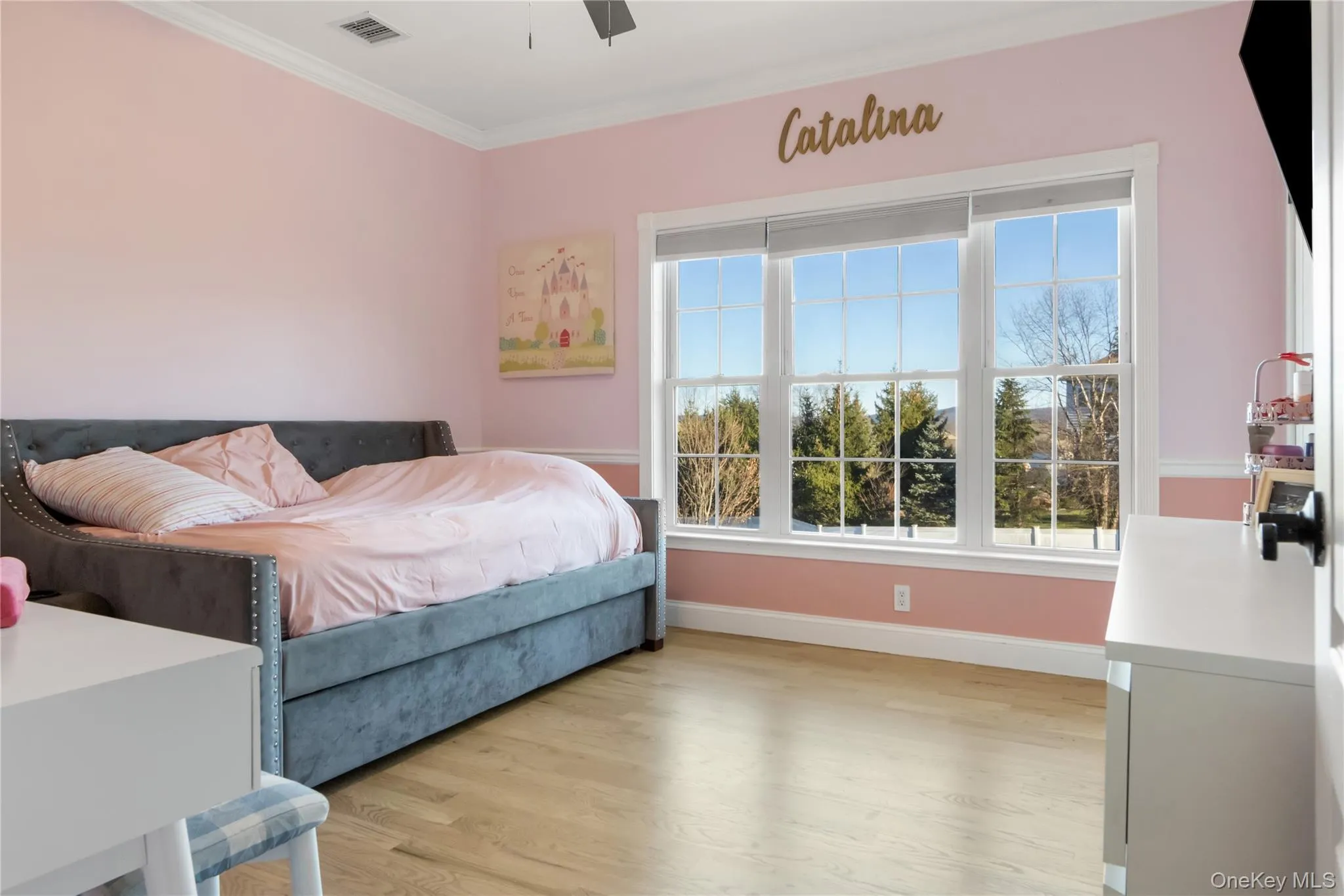 Bedroom with ornamental molding, light wood-type flooring, and ceiling fan Bedroom with ornamental molding, light wood-type flooring, and ceiling fan