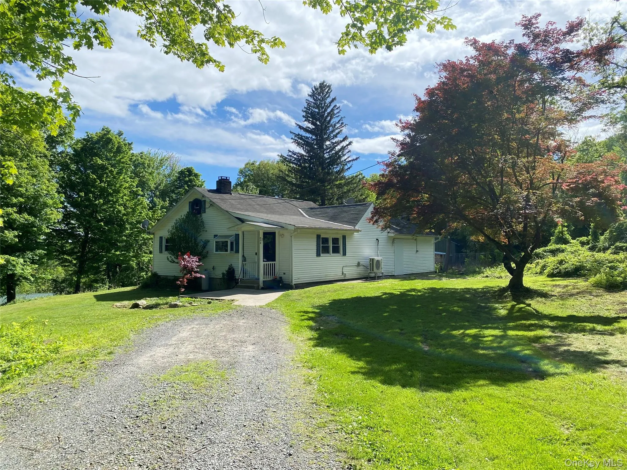 View of front facade featuring gravel driveway, a chimney, a front lawn, and central AC View of front facade featuring gravel driveway, a chimney, a front lawn, and central AC