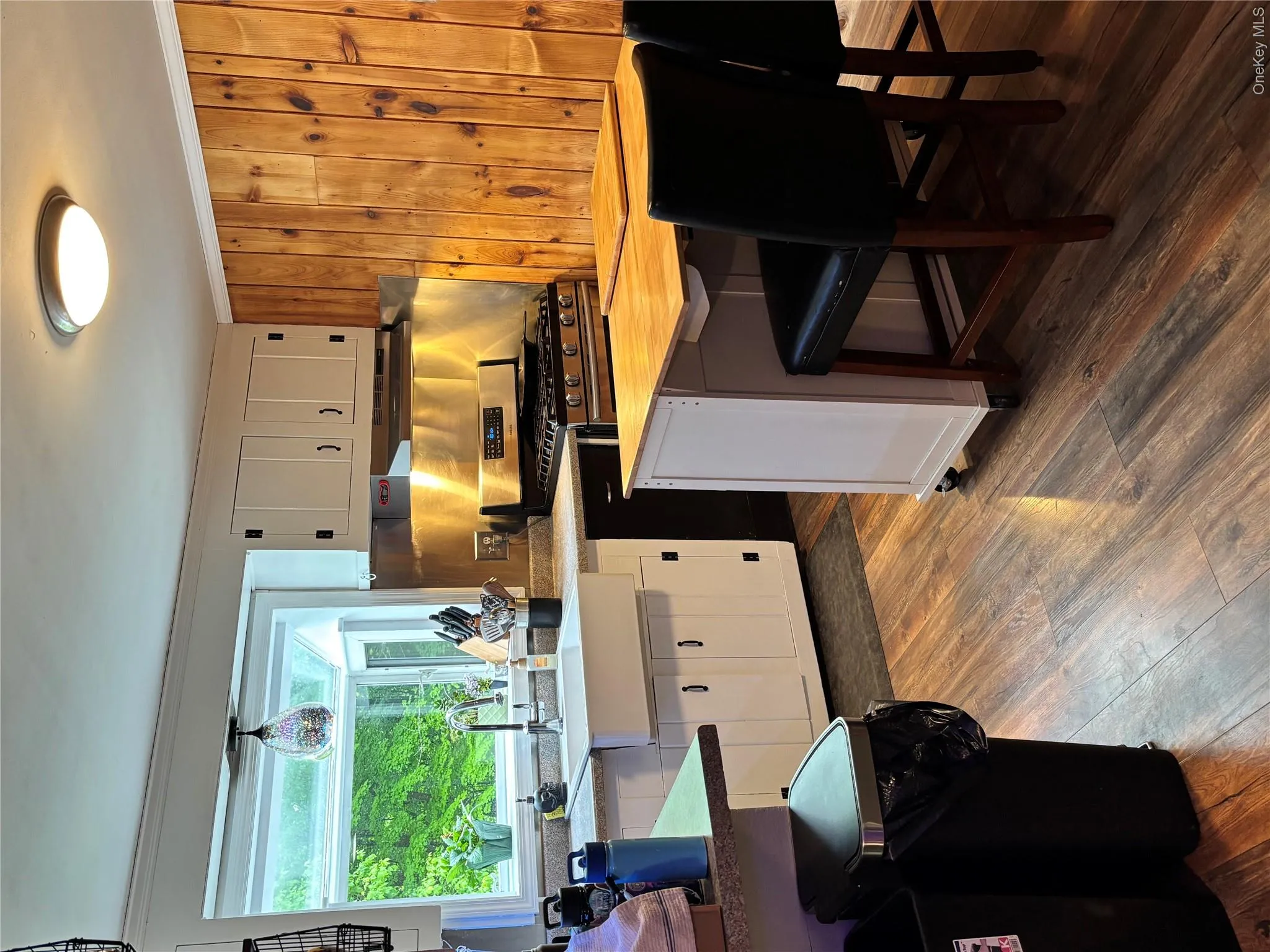 Kitchen featuring stove, butcher block countertops, a sink, dark wood-style flooring, and white cabinets Kitchen featuring stove, butcher block countertops, a sink, dark wood-style flooring, and white cabinets