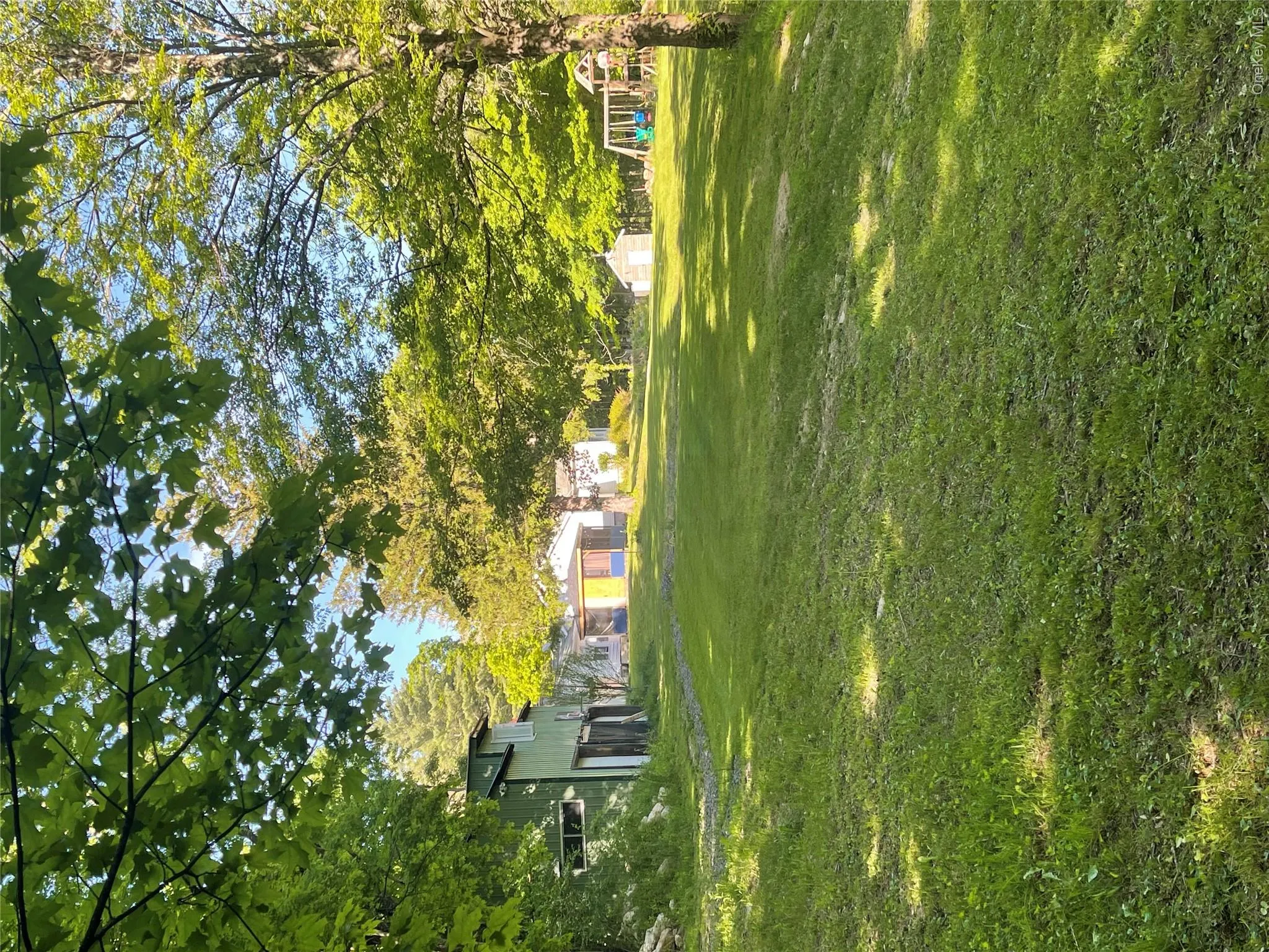 View of grassy yard featuring an outdoor structure and a playground View of grassy yard featuring an outdoor structure and a playground
