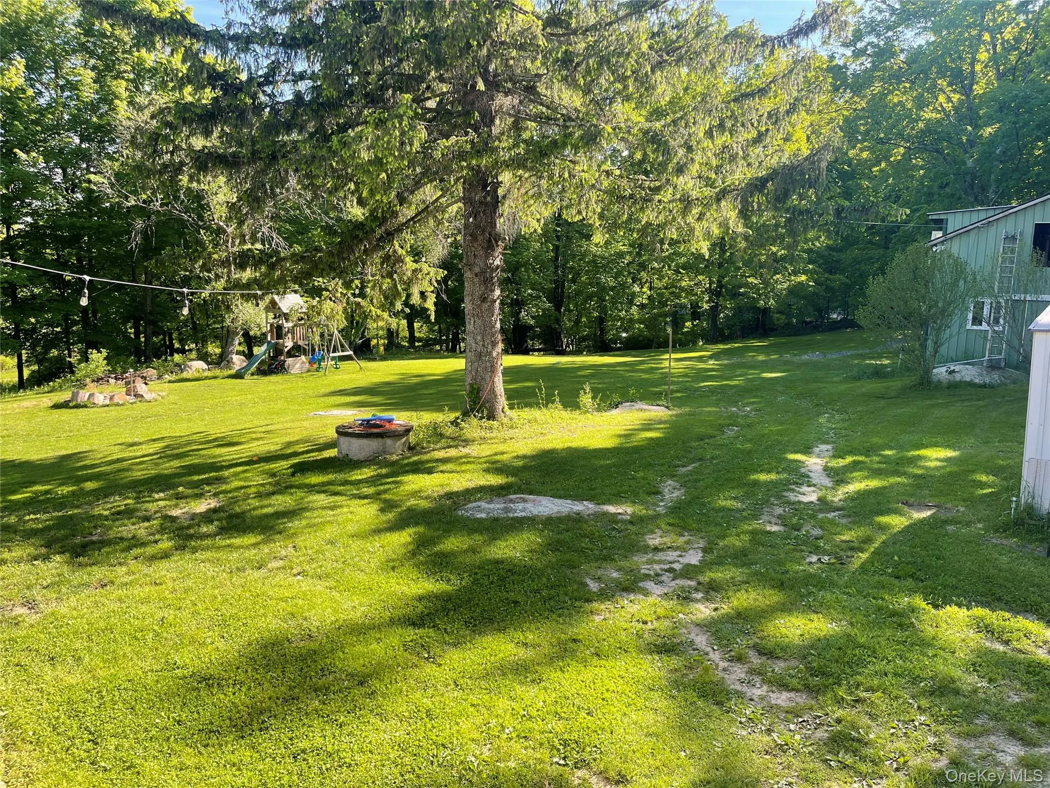 View of green lawn with a playground View of green lawn with a playground