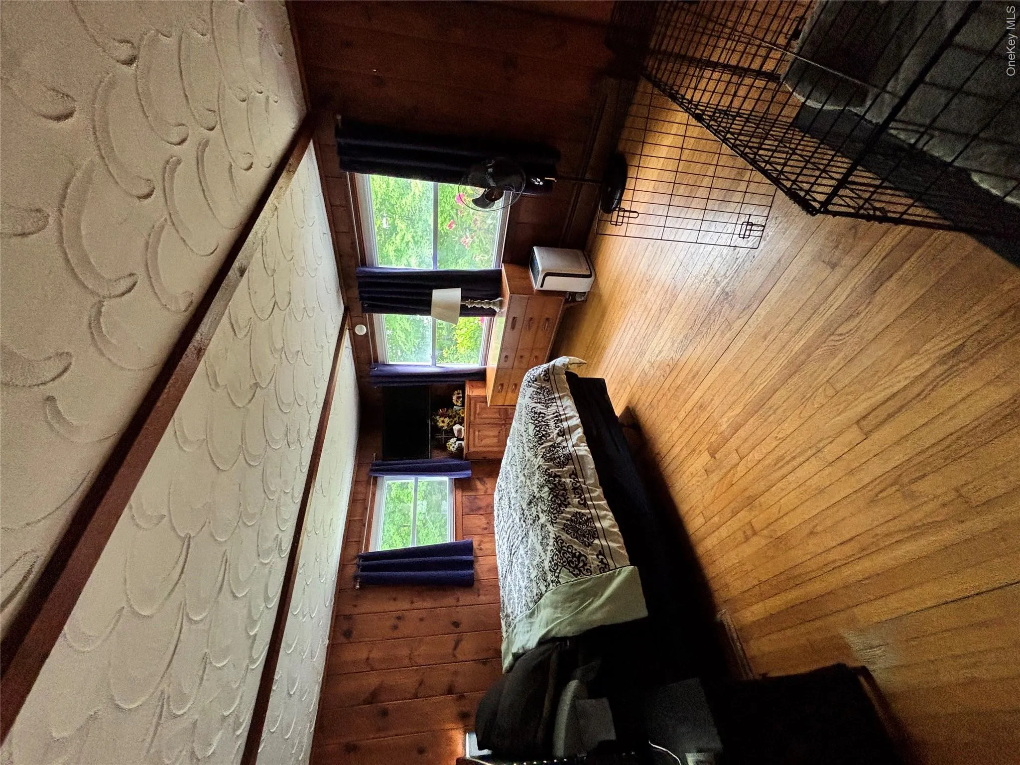 Bedroom with wooden walls and light wood-type flooring Bedroom with wooden walls and light wood-type flooring