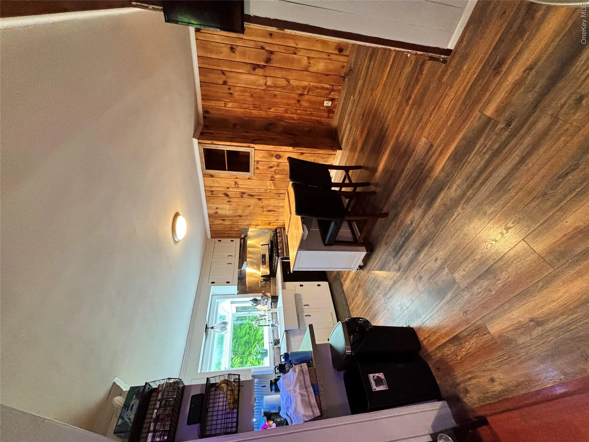 Kitchen with dark wood-type flooring, white cabinetry, stove, light countertops, and a breakfast bar area Kitchen with dark wood-type flooring, white cabinetry, stove, light countertops, and a breakfast bar area