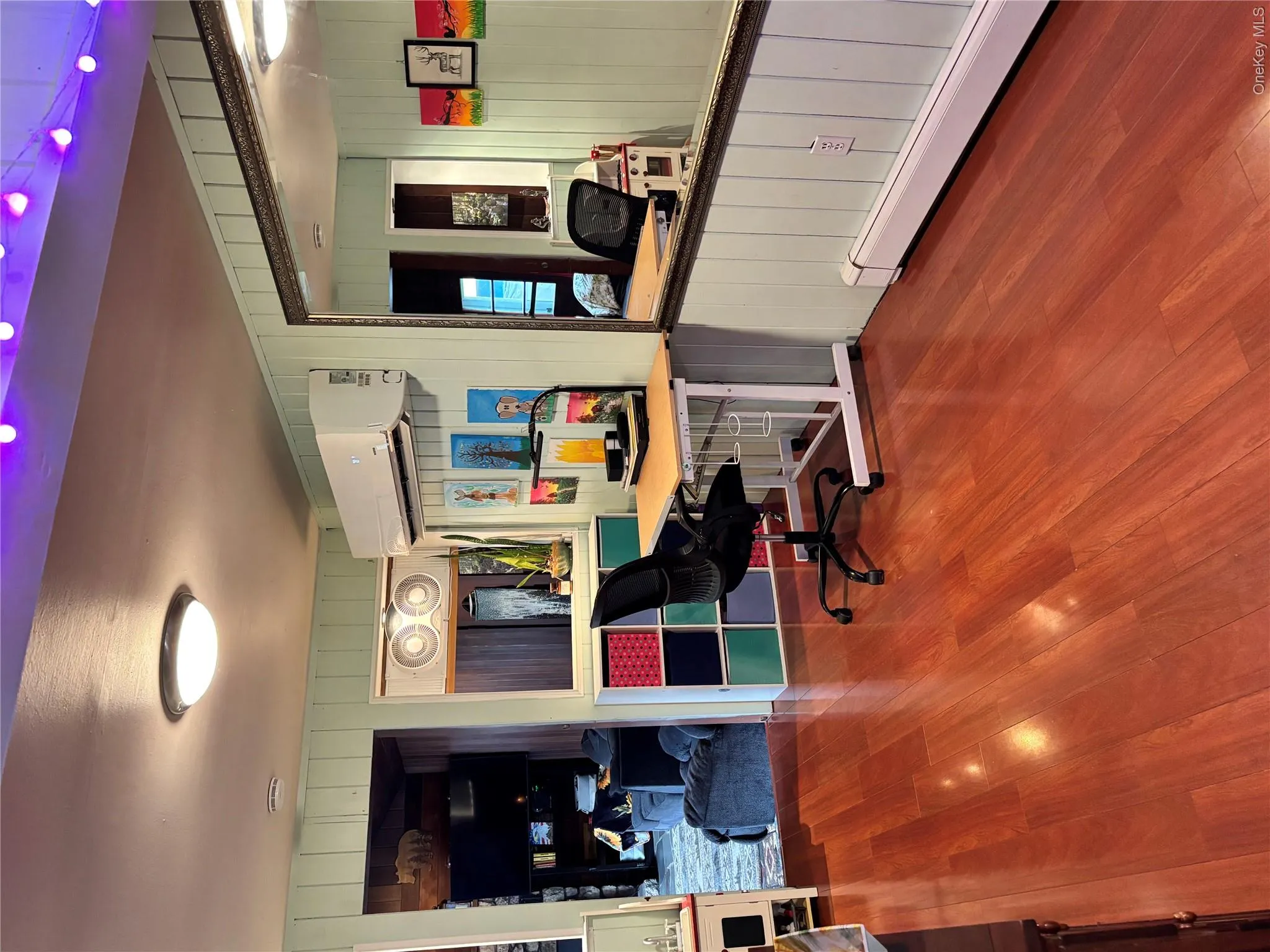 Office space featuring a wall unit AC, wood finished floors, and wooden walls Office space featuring a wall unit AC, wood finished floors, and wooden walls