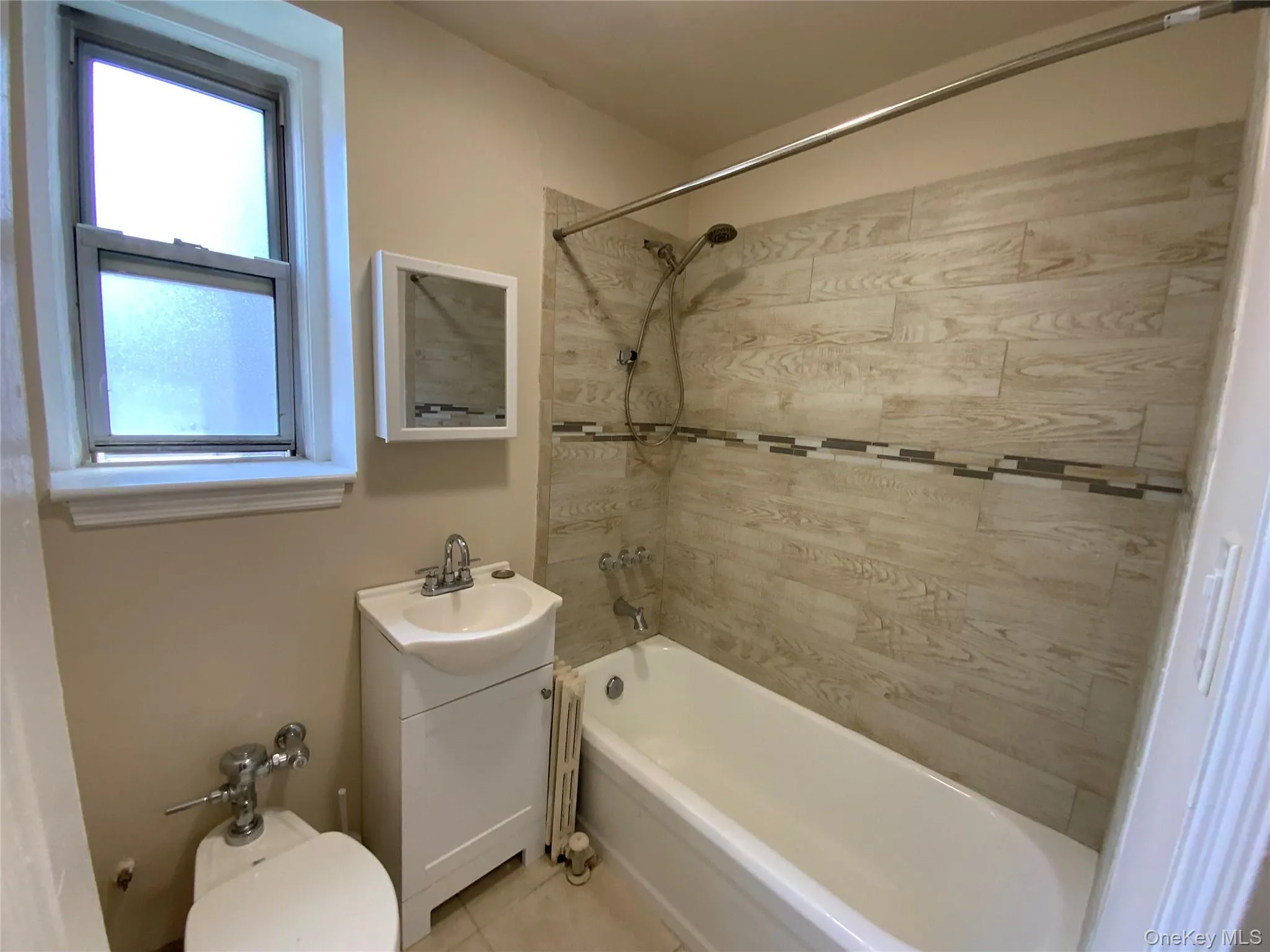 Full bathroom with tile patterned flooring, vanity, and bathing tub / shower combination Full bathroom with tile patterned flooring, vanity, and bathing tub / shower combination
