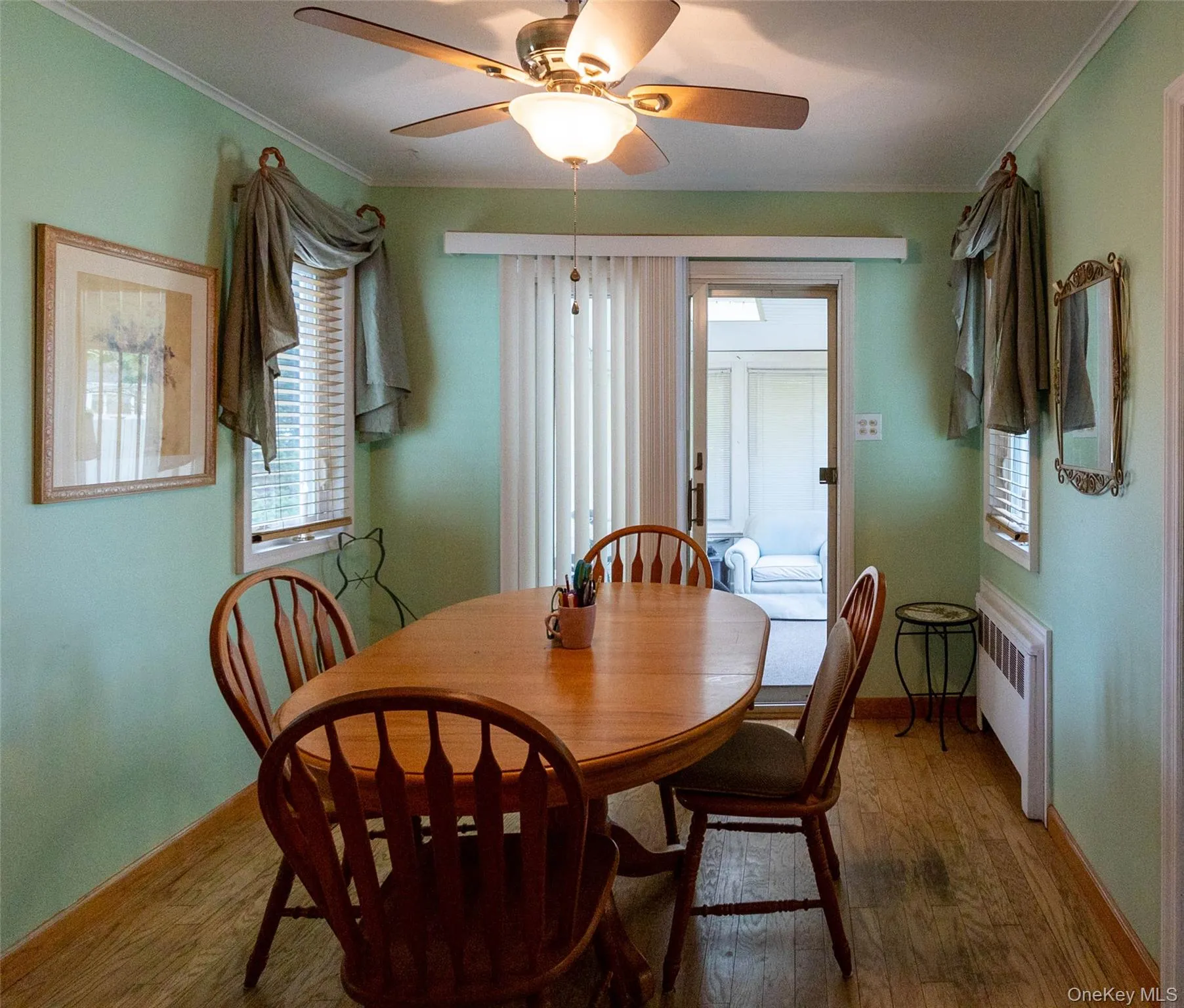 Dining area featuring wood-finish flooring and a ceiling fan with integrated lighting Dining area featuring wood-finish flooring and a ceiling fan with integrated lighting