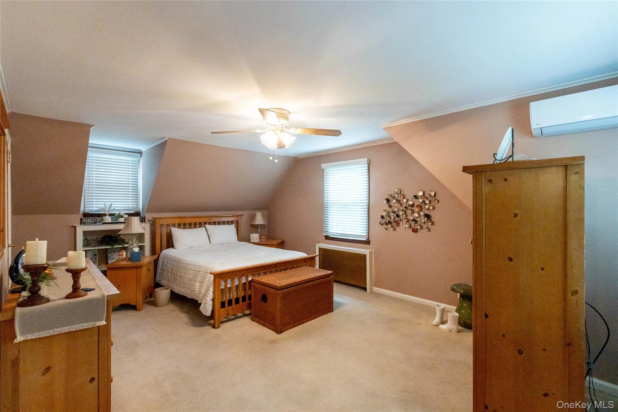 Carpeted room with sloped ceilings and a ceiling fan light fixture Carpeted room with sloped ceilings and a ceiling fan light fixture
