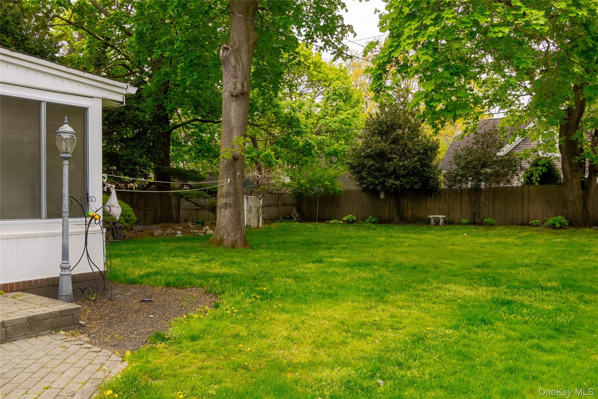 Expansive backyard featuring a manicured lawn, mature trees, and a privacy fence Expansive backyard featuring a manicured lawn, mature trees, and a privacy fence