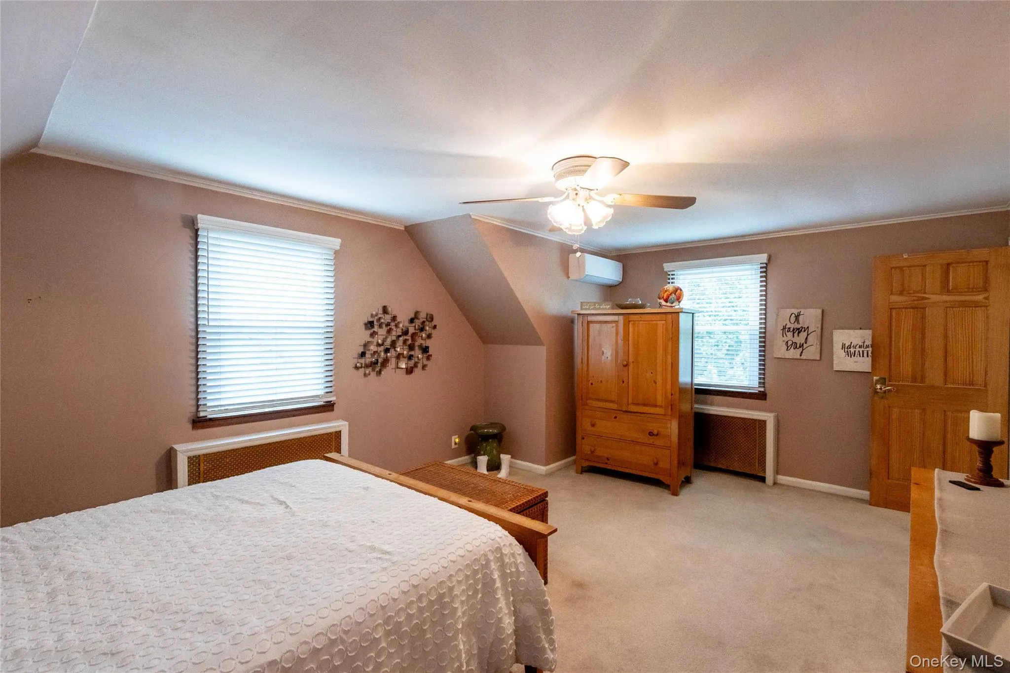 Carpeted room featuring sloped ceilings and a ceiling fan with integrated lighting Carpeted room featuring sloped ceilings and a ceiling fan with integrated lighting
