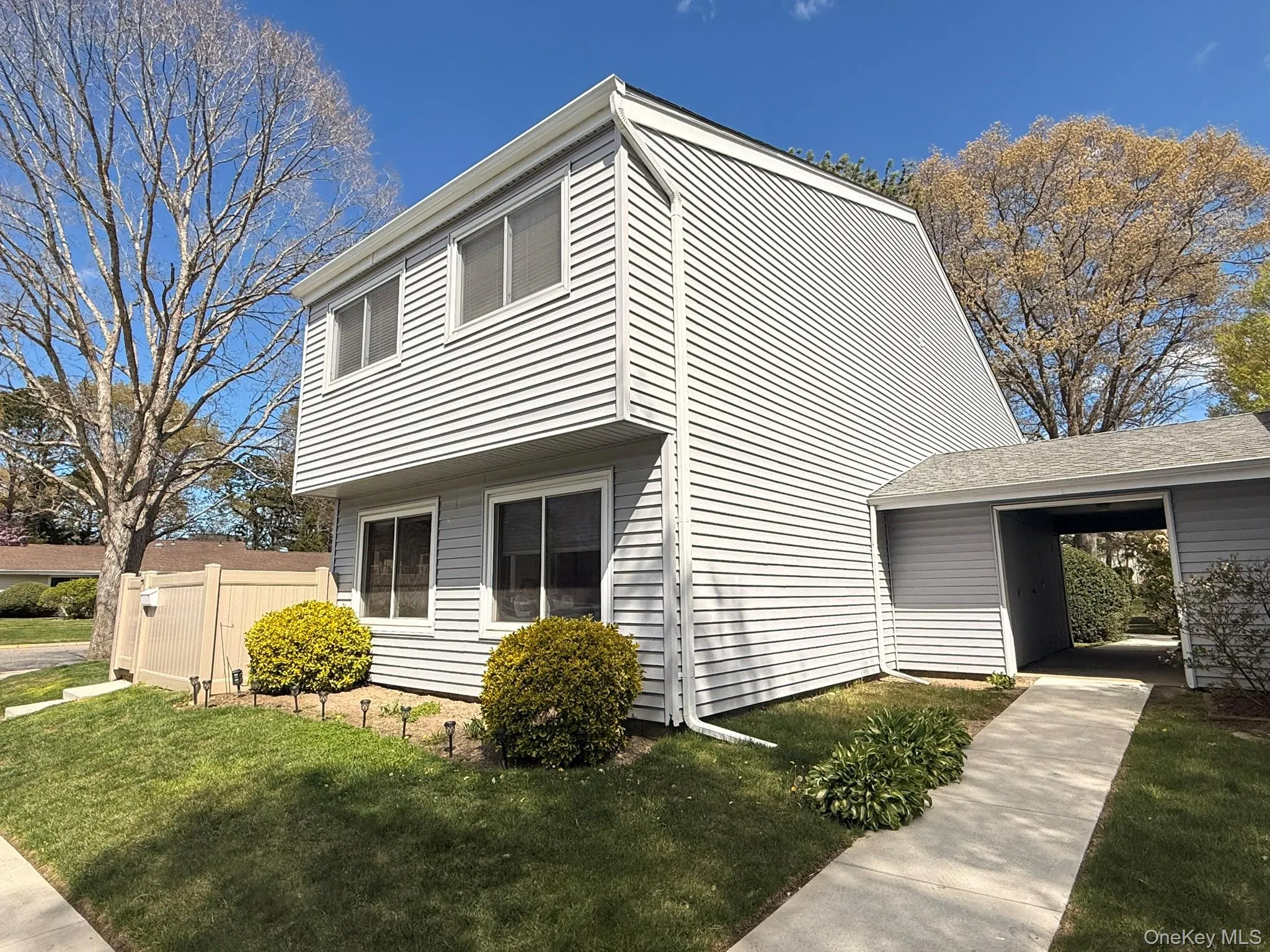 Two-story residence featuring light gray siding and white trim Two-story residence featuring light gray siding and white trim