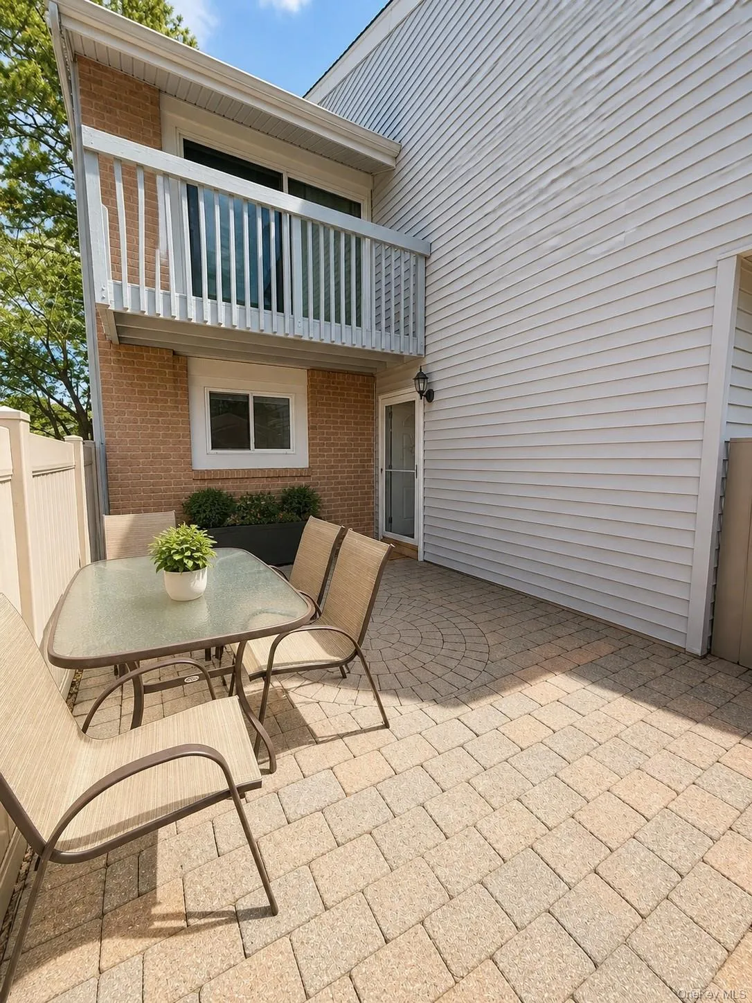 Paver patio with a radial design, featuring a partial privacy fence Paver patio with a radial design, featuring a partial privacy fence