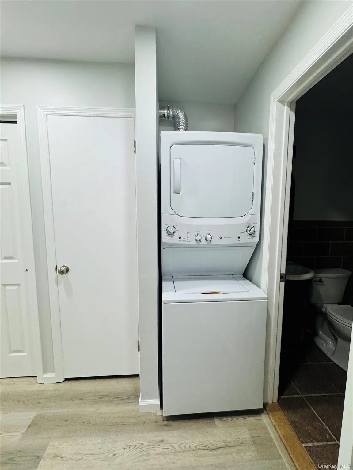 Laundry area featuring a white stacked washer and dryer unit Laundry area featuring a white stacked washer and dryer unit