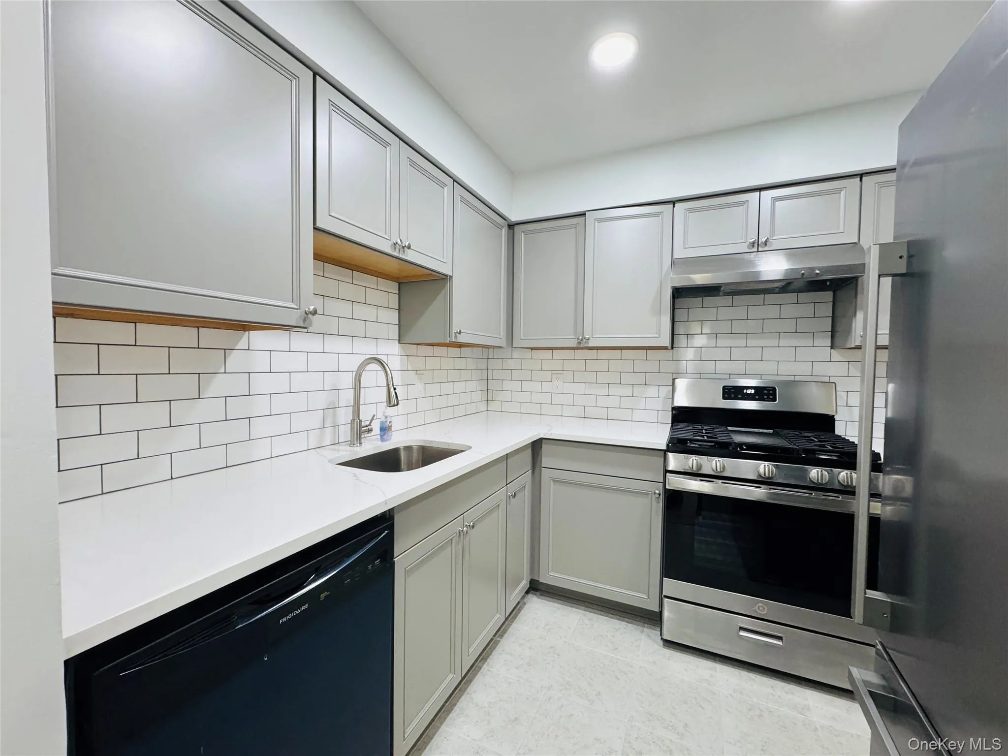 Walk through Modern Kitchen with ceramic tile flooring, new cabinets, subway tile backsplash, stainless steel dishwasher, range and refrigerator. Walk through Modern Kitchen with ceramic tile flooring, new cabinets, subway tile backsplash, stainless steel dishwasher, range and refrigerator.