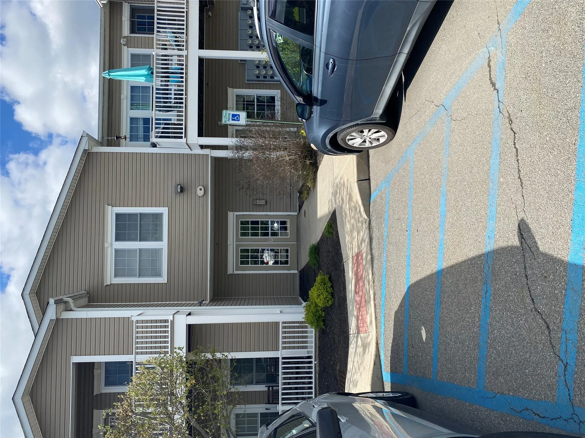 Multi-level building with tan siding and white trim Multi-level building with tan siding and white trim