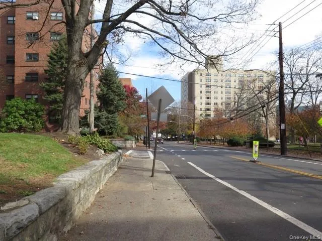 View of asphalt street featuring sidewalks, traffic signs, and curbs View of asphalt street featuring sidewalks, traffic signs, and curbs
