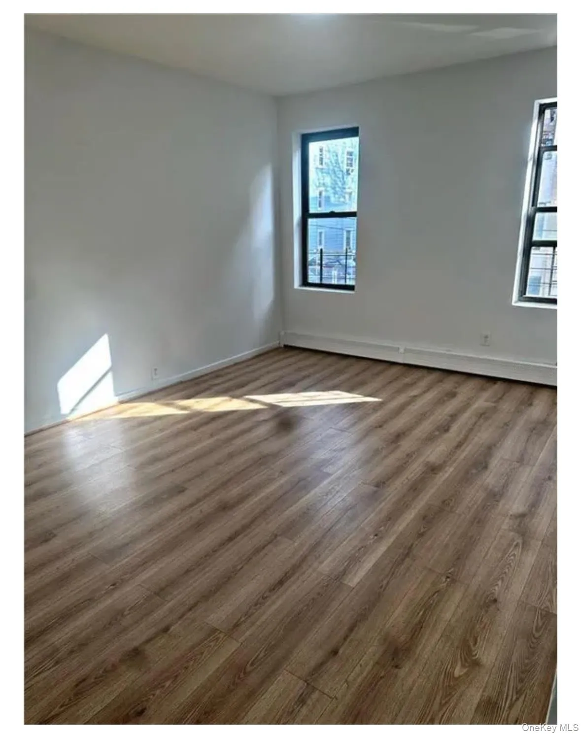 Unfurnished room with dark wood-style floors and baseboards Unfurnished room with dark wood-style floors and baseboards