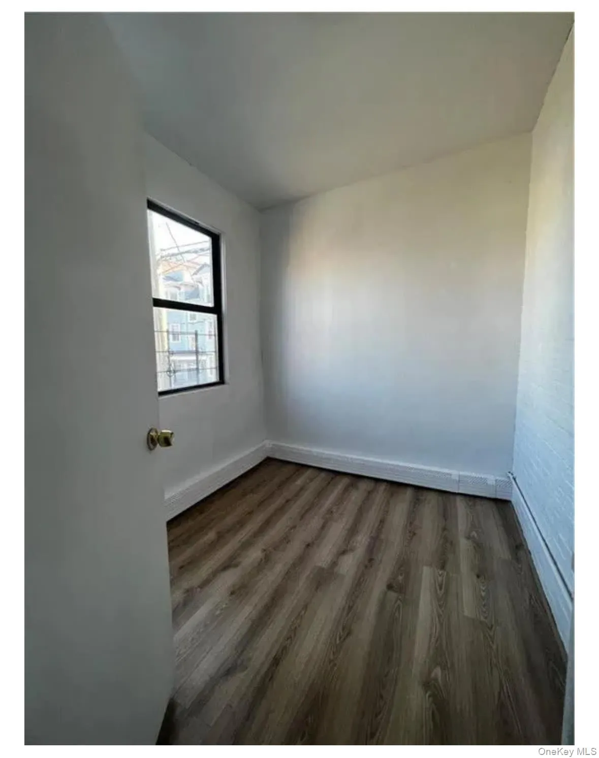 Spare room with wood finished floors and baseboards Spare room with wood finished floors and baseboards