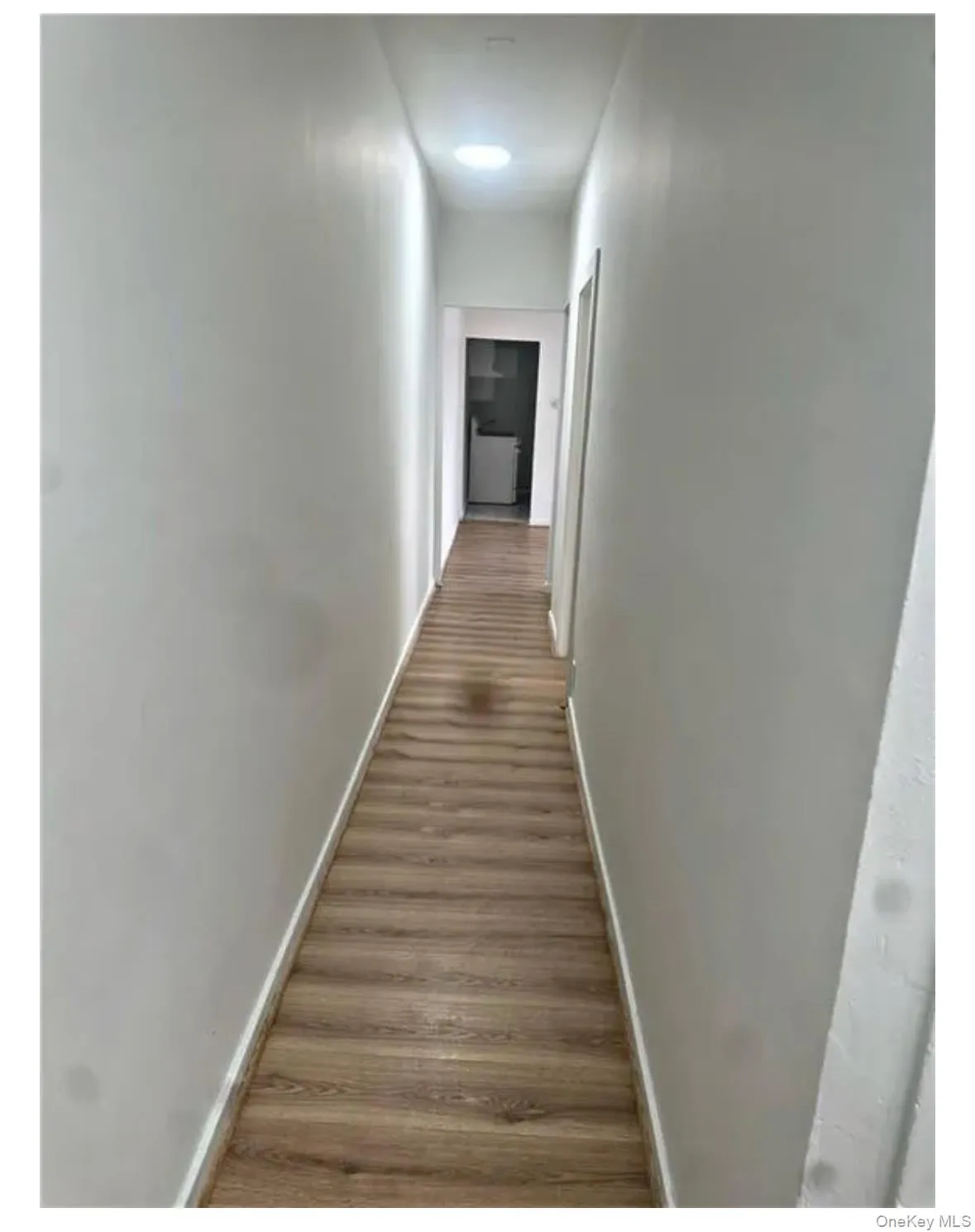 Hallway featuring wood finished floors and baseboards Hallway featuring wood finished floors and baseboards