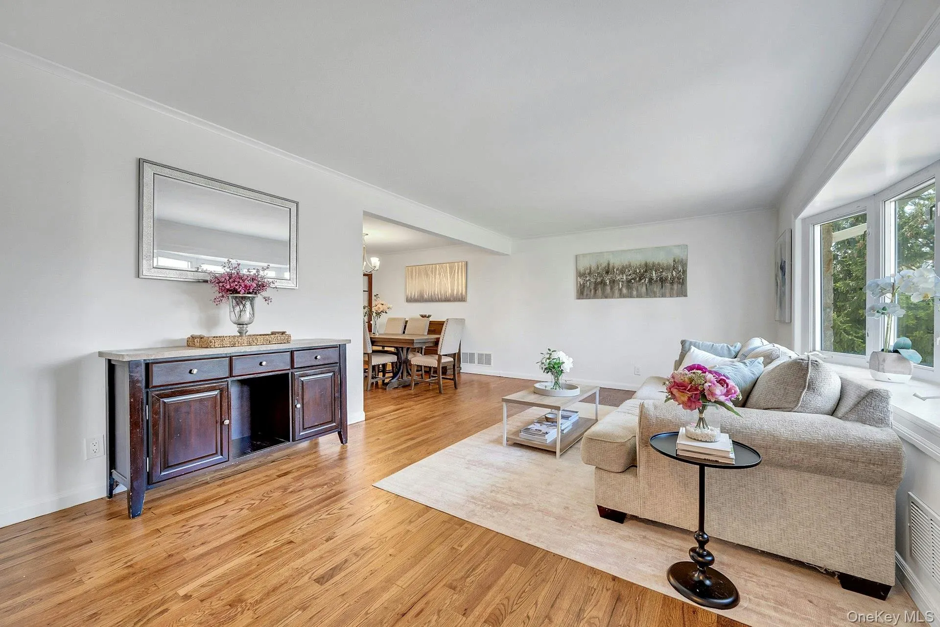 Sun-drenched living room with beautifully redone hardwood floors Sun-drenched living room with beautifully redone hardwood floors