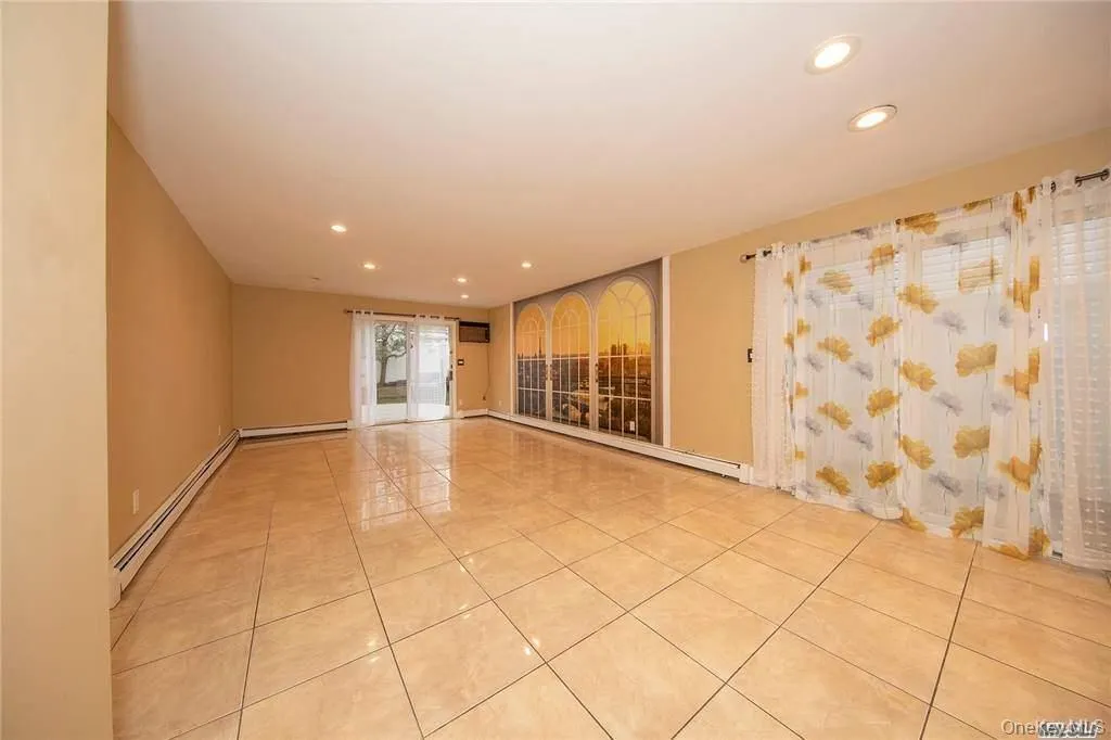 Den with tile floors. Sliders leading to patio area outside. Den with tile floors. Sliders leading to patio area outside.