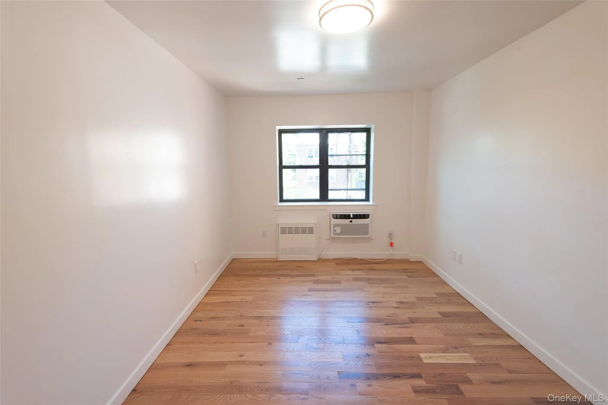 Bright second bedroom with hardwood floors and one closet Bright second bedroom with hardwood floors and one closet