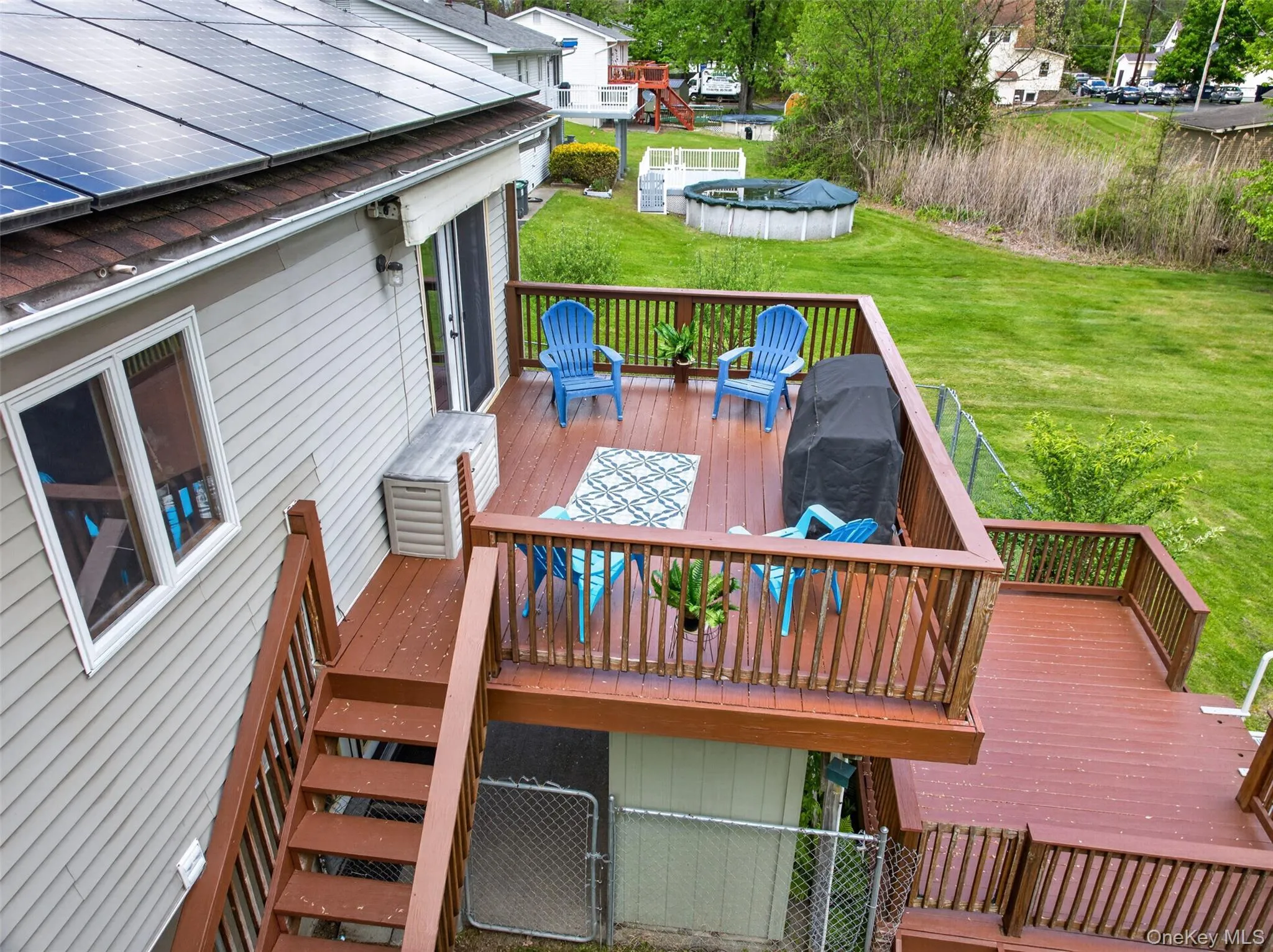 Multi-level wood deck featuring a railing system and access to the expansive yard, French doors that lead to kitchen, and Automatic retractable Awning. Multi-level wood deck featuring a railing system and access to the expansive yard, French doors that lead to kitchen, and Automatic retractable Awning.