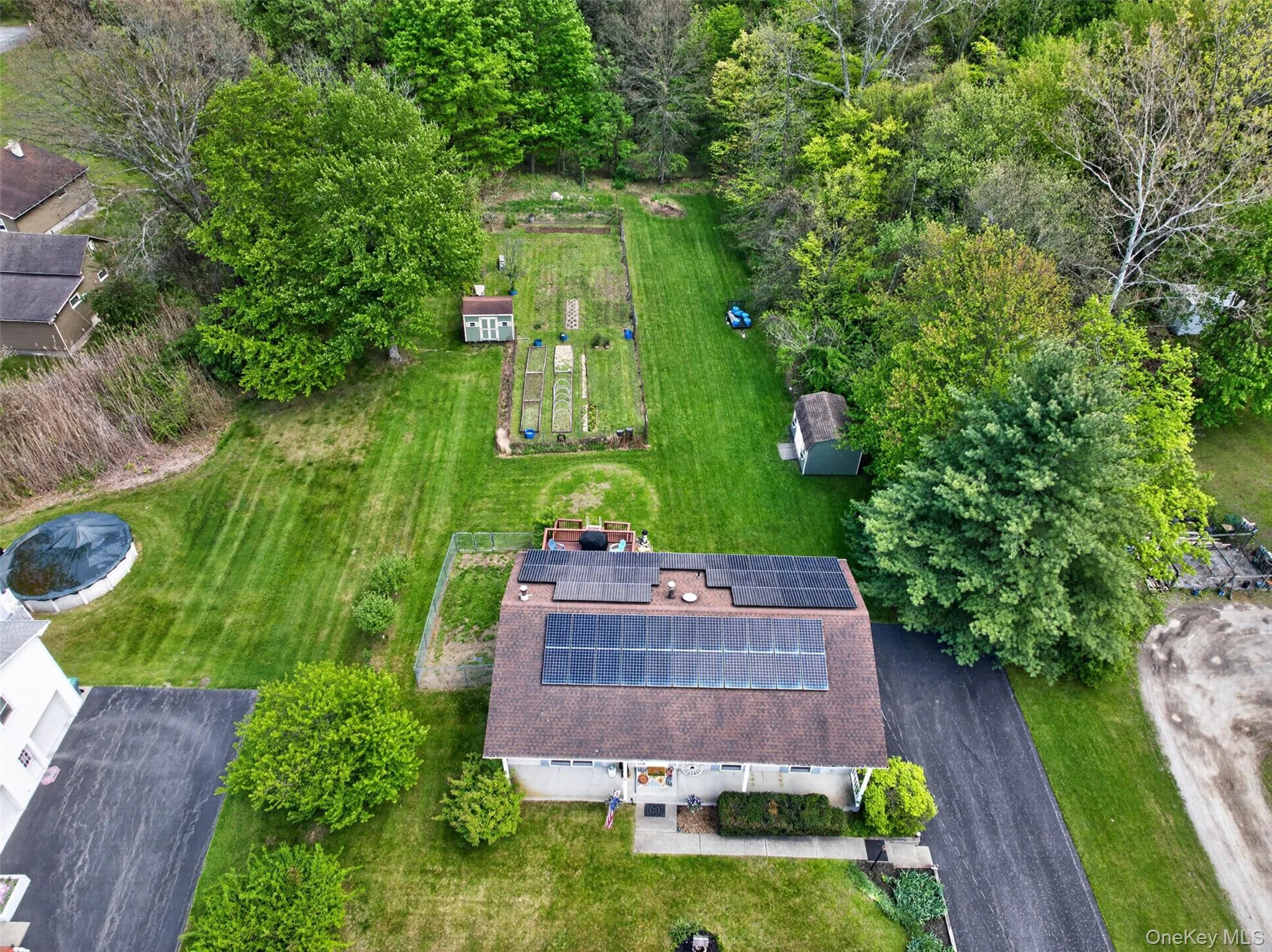 Single-story residence featuring a shingled roof with solar panels and large yard for your entertainment Single-story residence featuring a shingled roof with solar panels and large yard for your entertainment