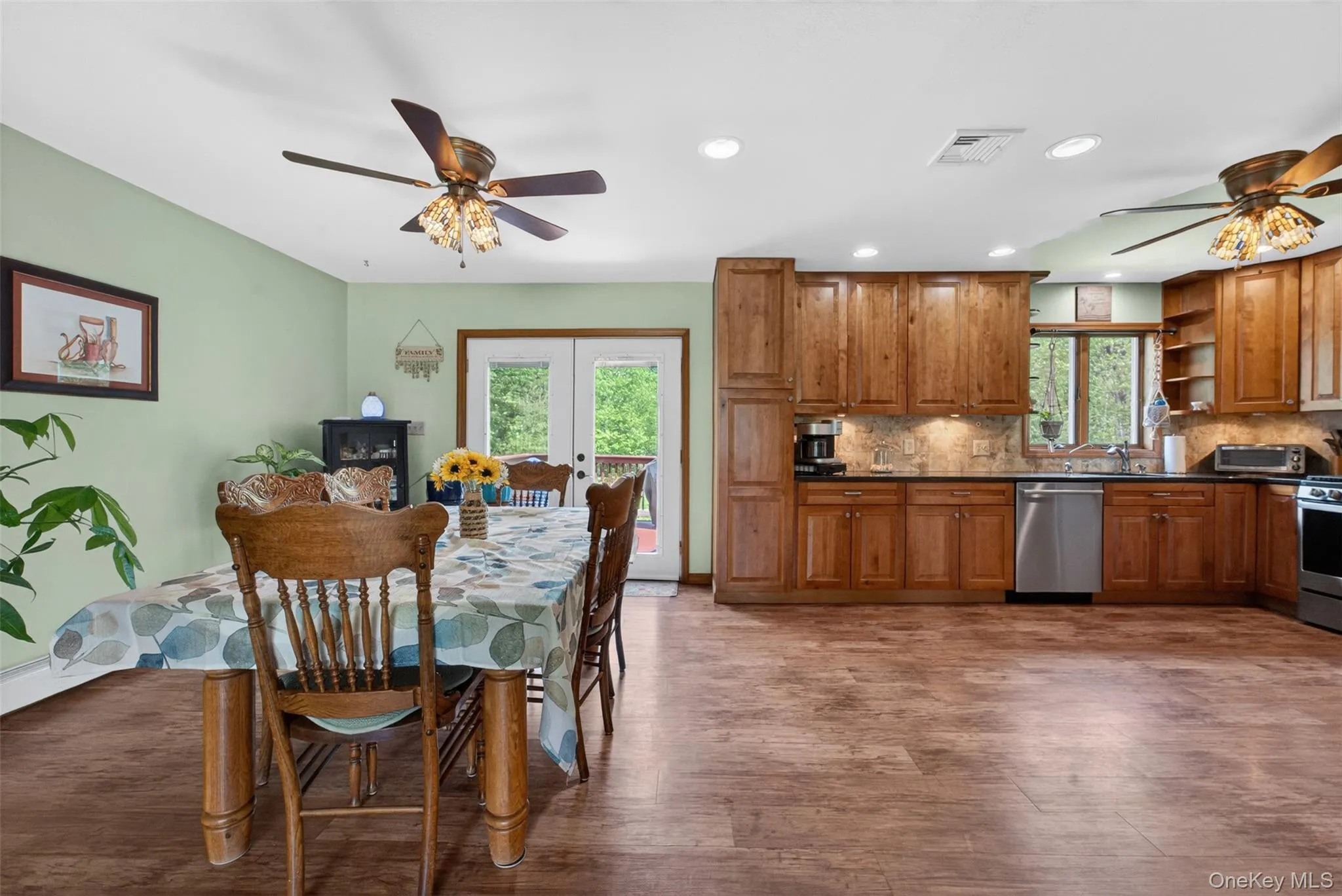 Open-concept kitchen and dining area featuring wood-finish flooring, recessed lighting, and a neutral wall color, and French Doors Leading out to Upper Deck for your enjoyment. Open-concept kitchen and dining area featuring wood-finish flooring, recessed lighting, and a neutral wall color, and French Doors Leading out to Upper Deck for your enjoyment.