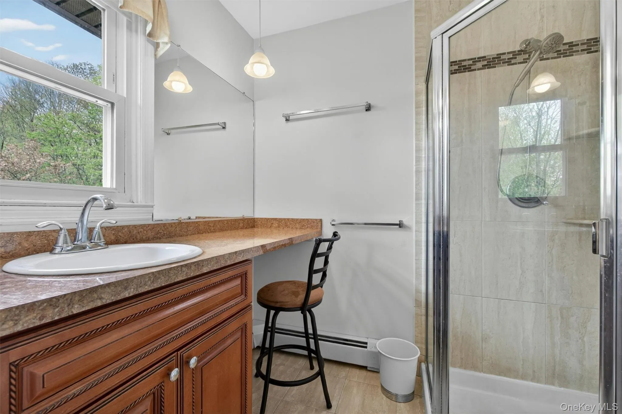 The primary bath features a tiled walk in shower and a vanity area. The primary bath features a tiled walk in shower and a vanity area.