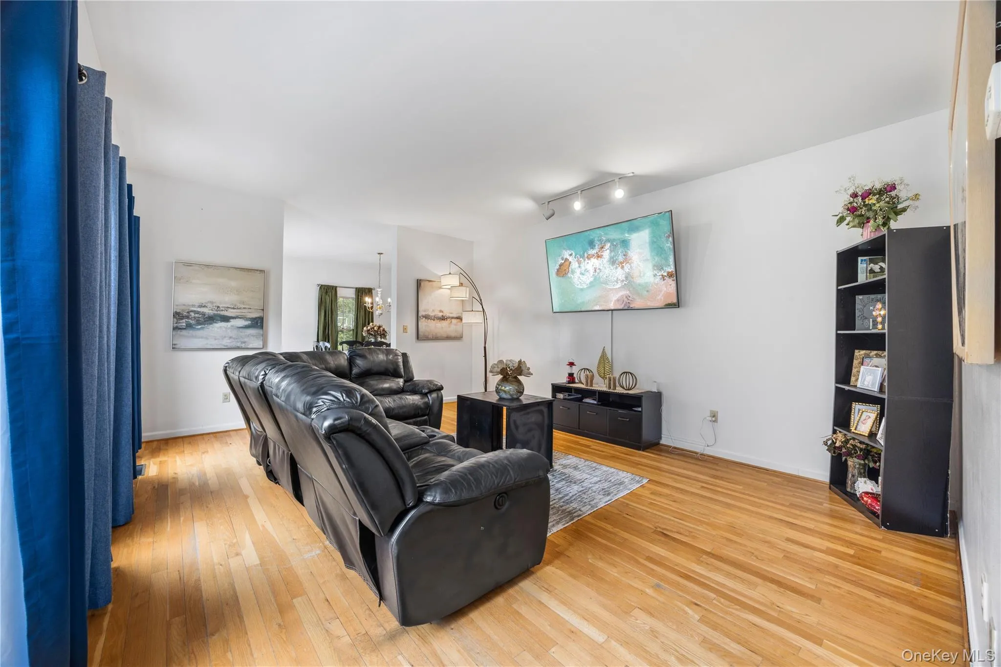 Hardwood-finish flooring throughout, featuring a recessed ceiling, track lighting, and a neutral color palette Hardwood-finish flooring throughout, featuring a recessed ceiling, track lighting, and a neutral color palette