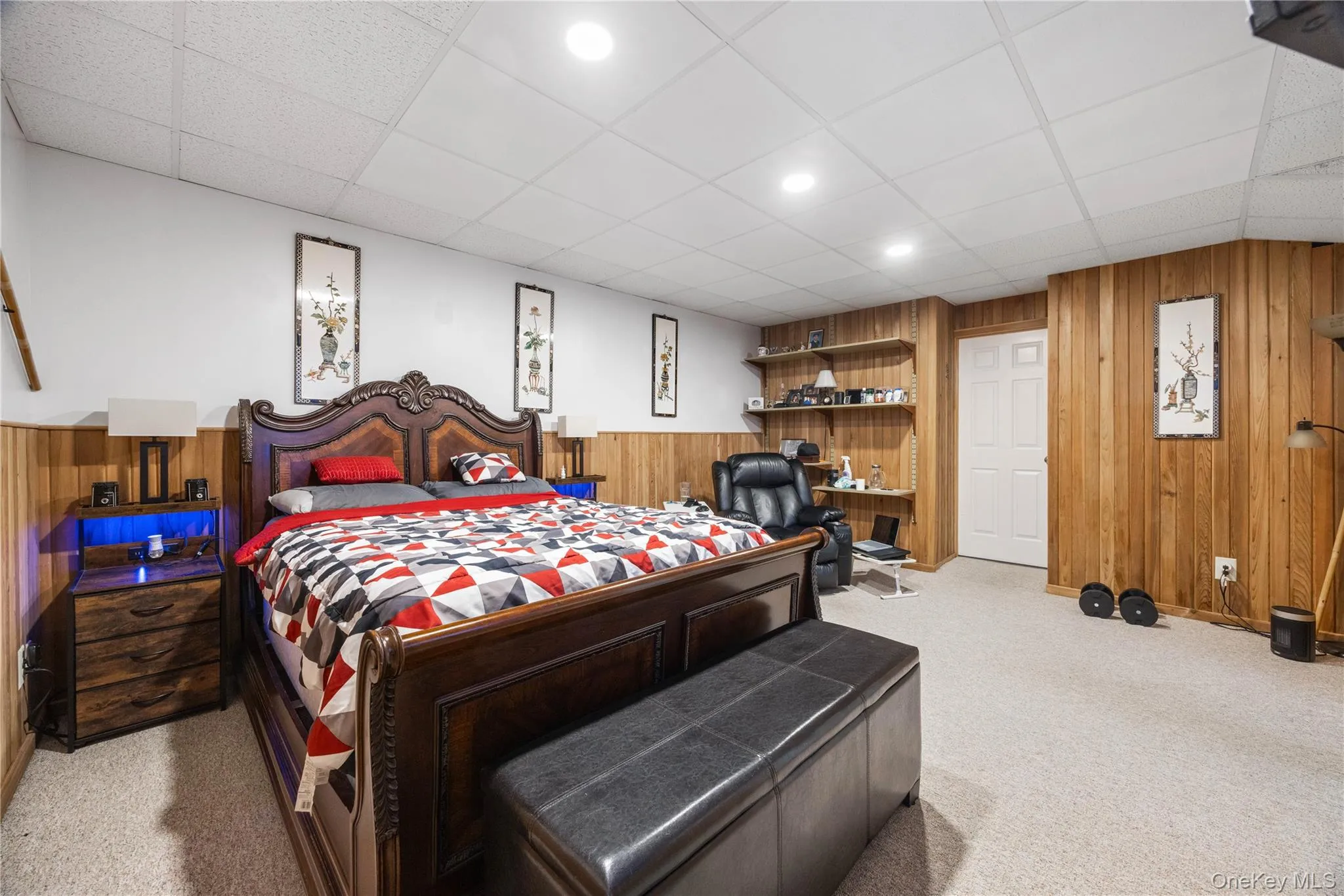 Carpeted room featuring a white drop ceiling with recessed lighting, wood paneling, and white walls Carpeted room featuring a white drop ceiling with recessed lighting, wood paneling, and white walls