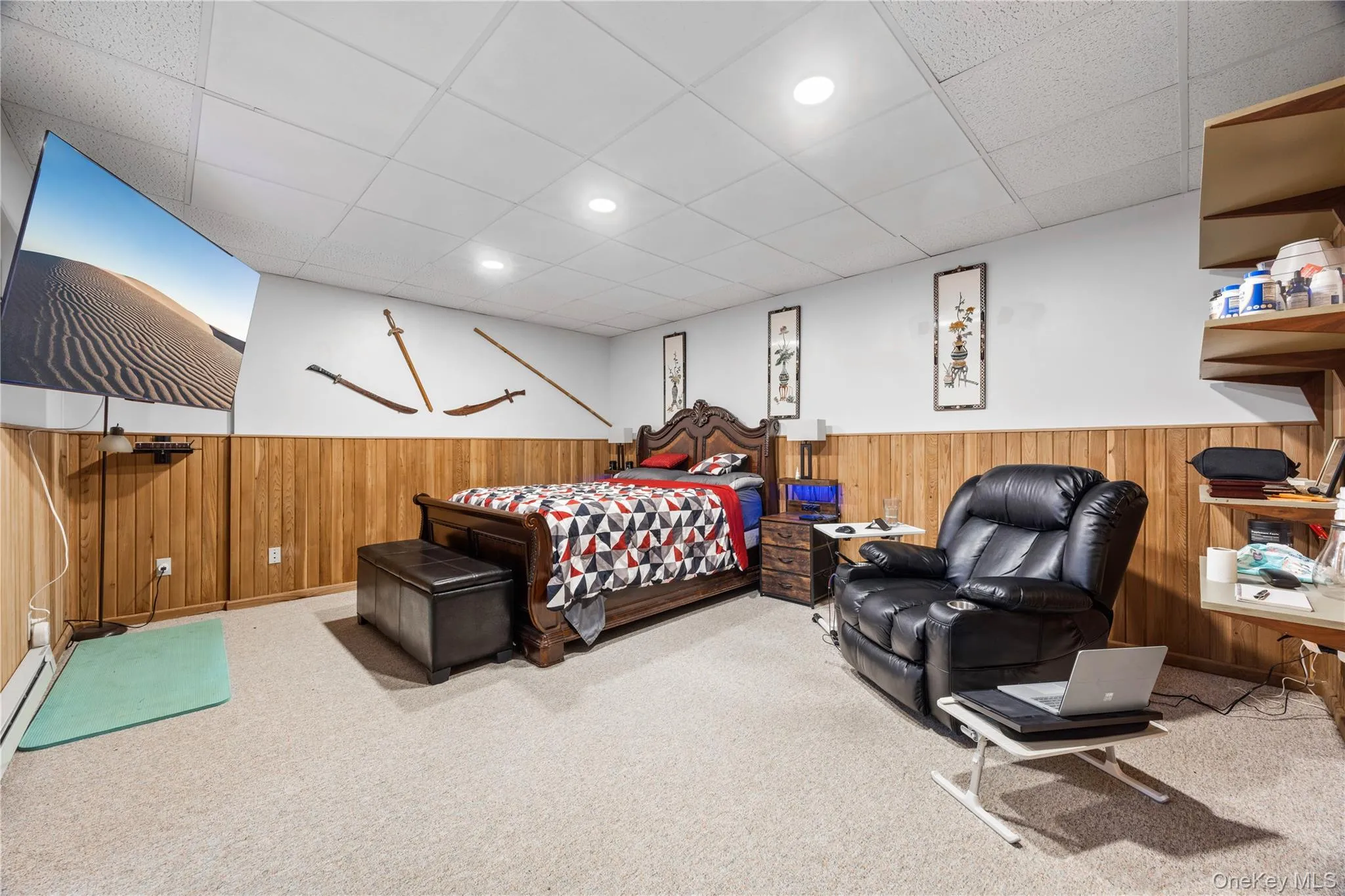 Carpeted room featuring wood-paneled wainscoting, recessed lighting, and a drop ceiling Carpeted room featuring wood-paneled wainscoting, recessed lighting, and a drop ceiling