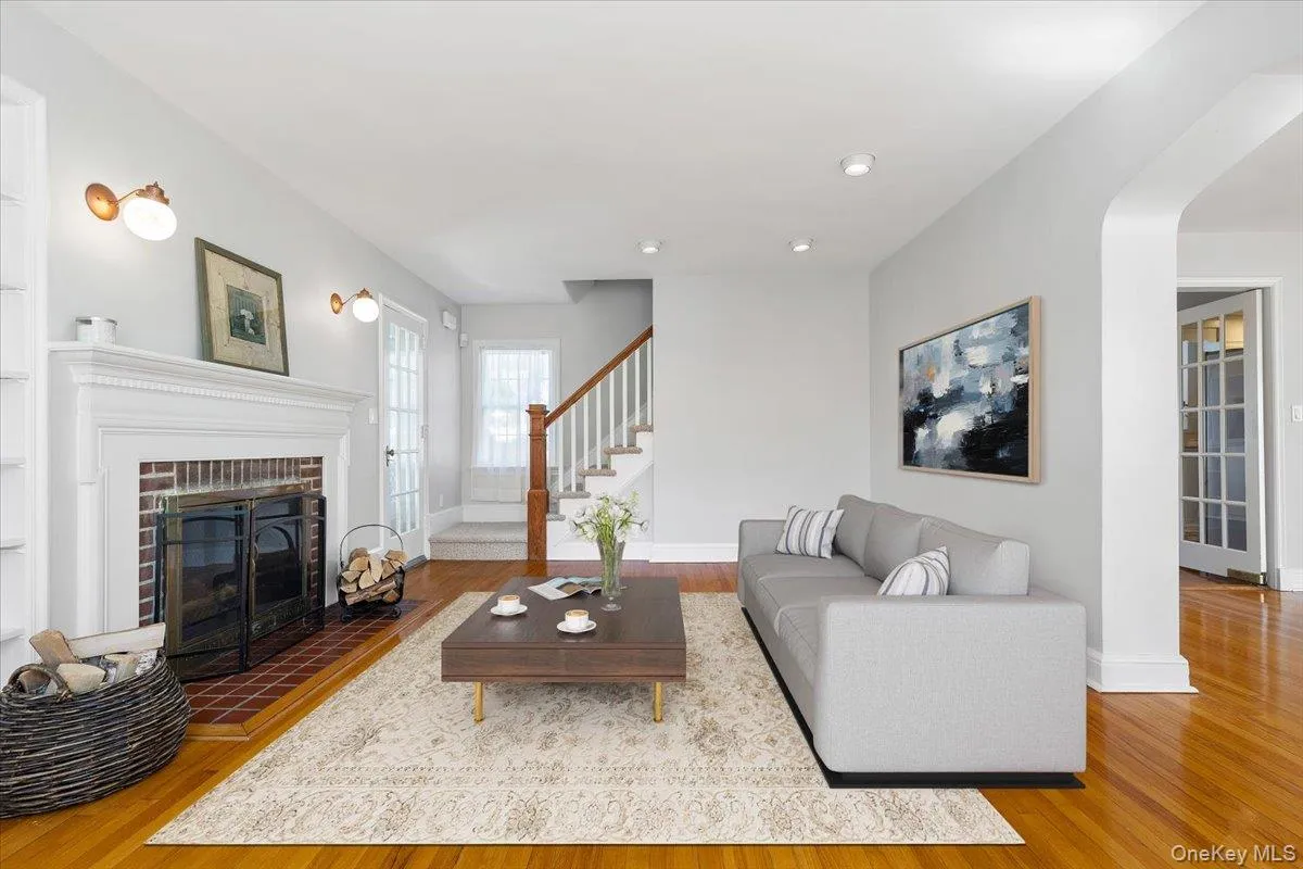 Virtually Staged Living Room featuring a wood-burning fireplace, and showing stairway to second floor bedrooms Virtually Staged Living Room featuring a wood-burning fireplace, and showing stairway to second floor bedrooms