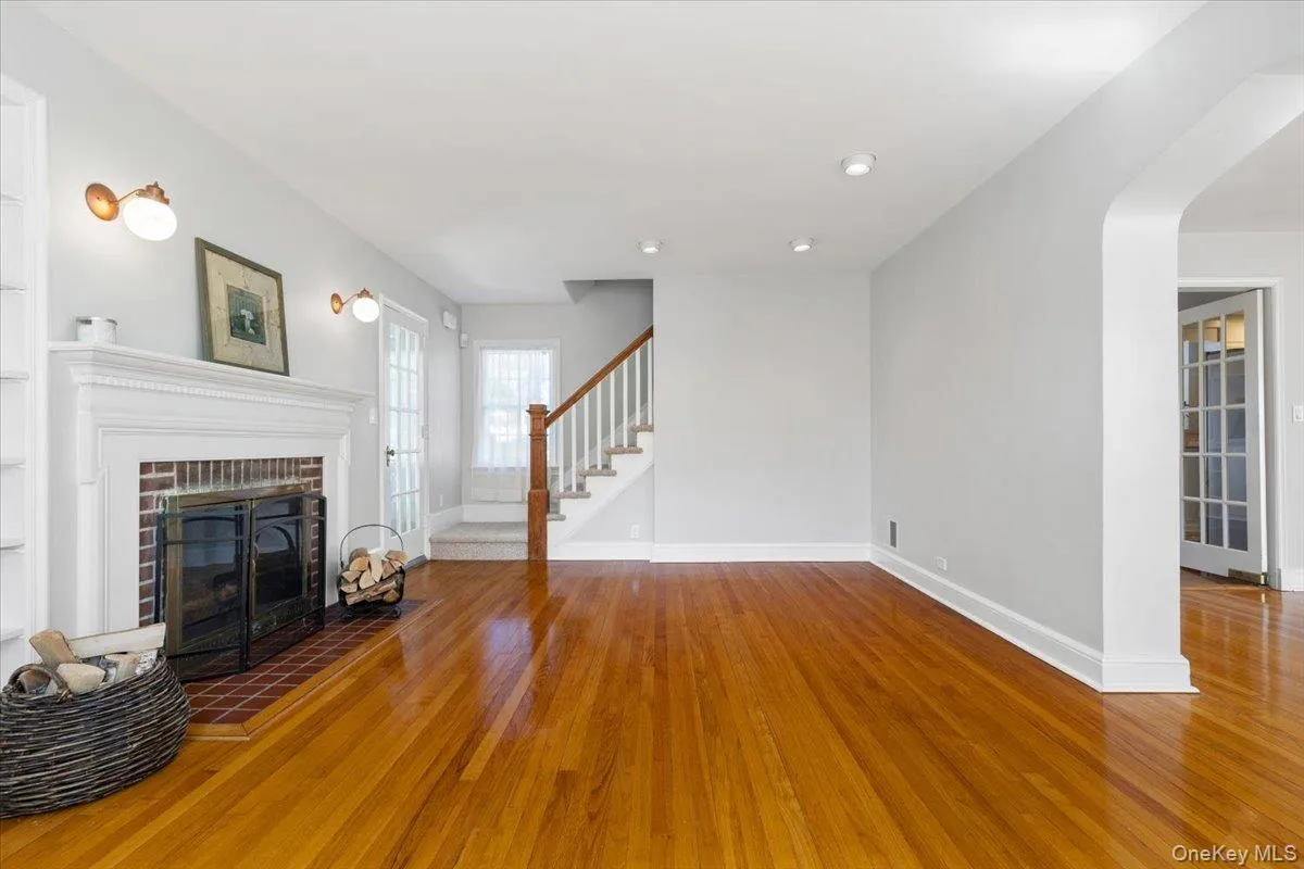 Living Room featuring a wood-burning fireplace, and showing stairway to second floor bedrooms Living Room featuring a wood-burning fireplace, and showing stairway to second floor bedrooms
