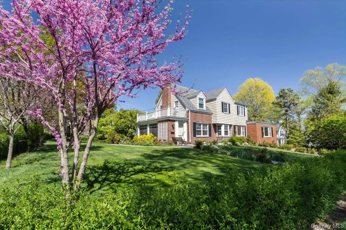 Step back and take in the beautifully landscaped front yard, classic brick façade, charming shutters, and elegant second-floor balcony Step back and take in the beautifully landscaped front yard, classic brick façade, charming shutters, and elegant second-floor balcony